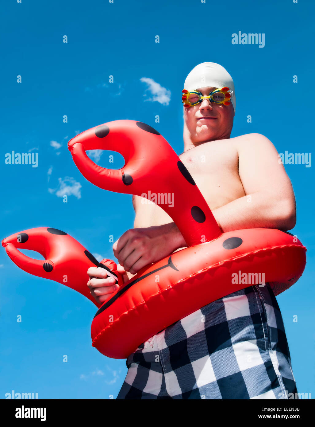 crazy and funny concept of a young man wearing kid's swimming gear Stock Photo
