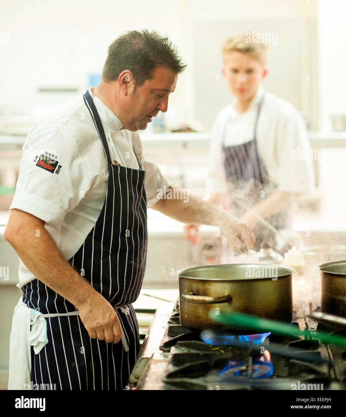 Chefs and kitchen staff working in a busy kitchen Stock Photo