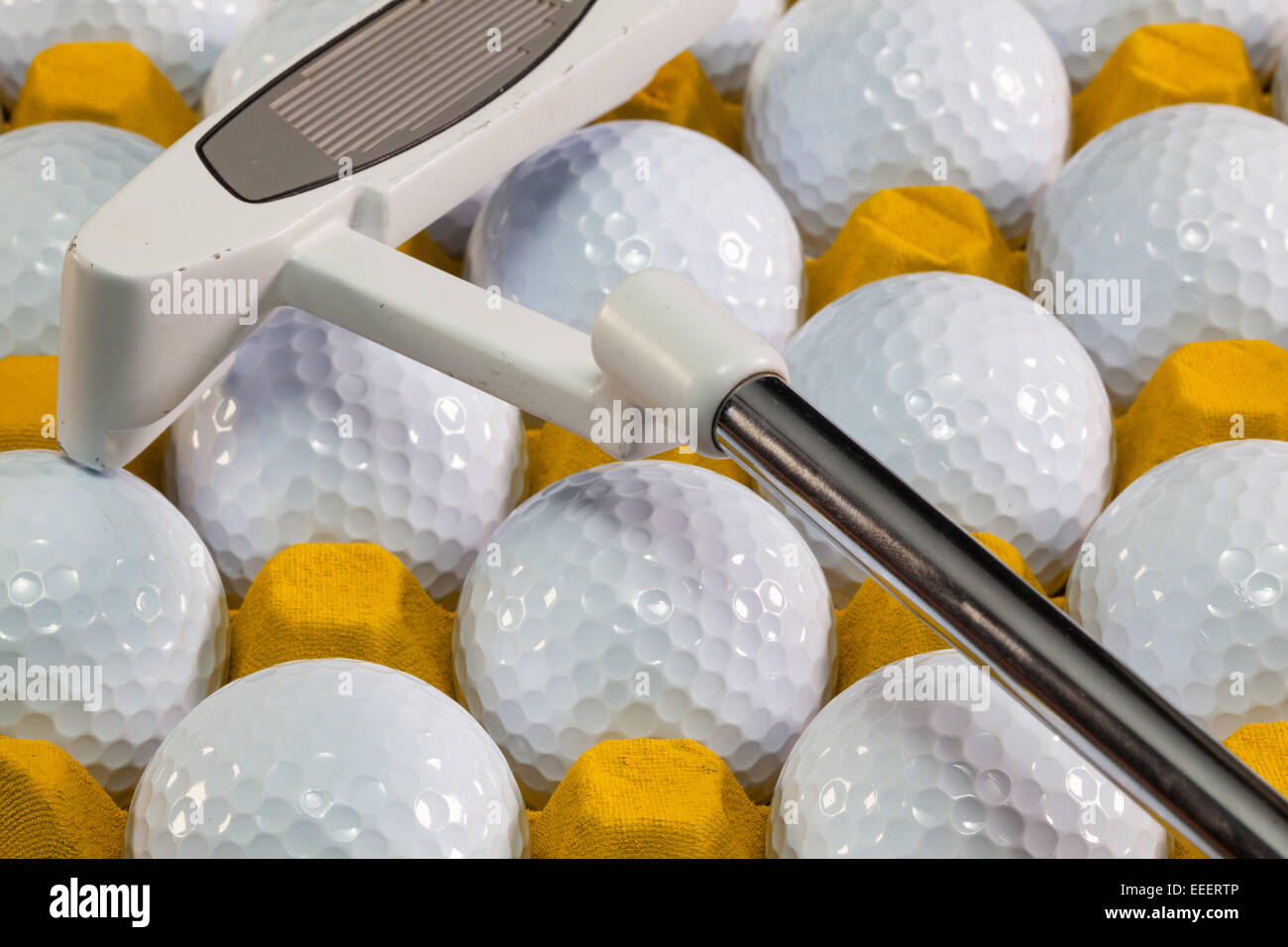 White golf balls in the yellow box and golf equipments Stock Photo