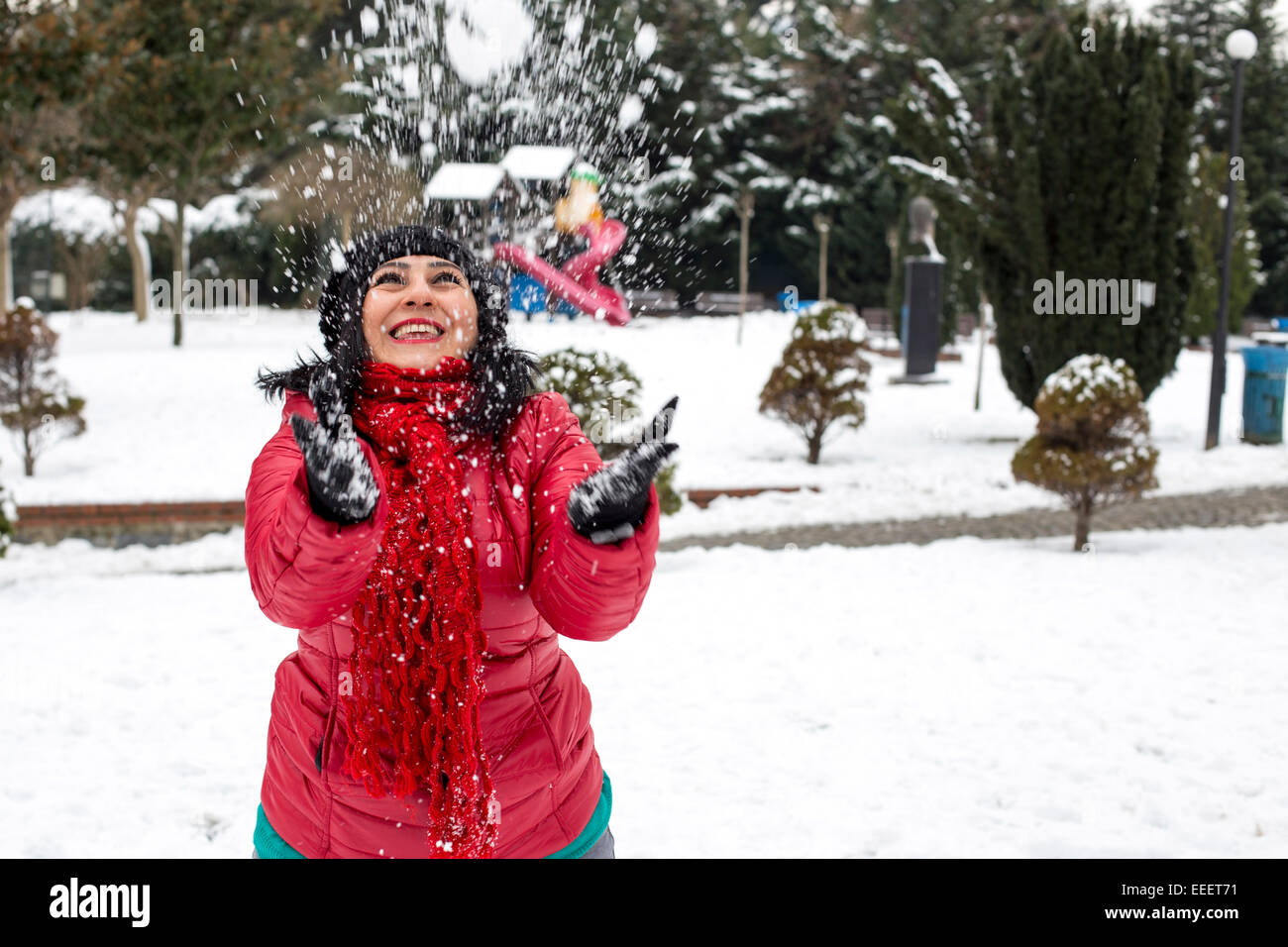Happy young Turkish woman plays with a snow outdoor in a winter day Stock Photo