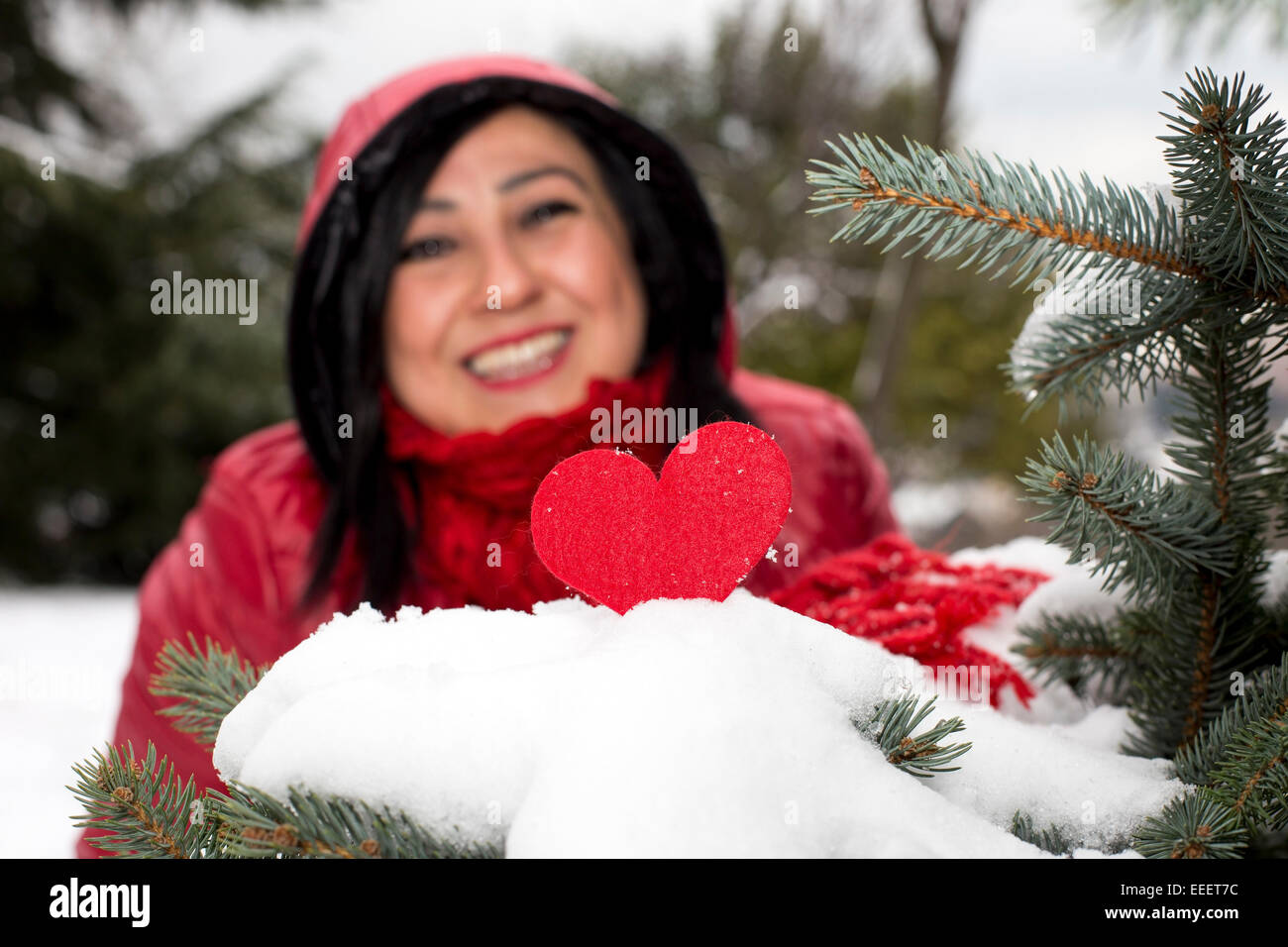 Black haired Turkish women looking at red heart and celebrating Valentine's day alone Stock Photo
