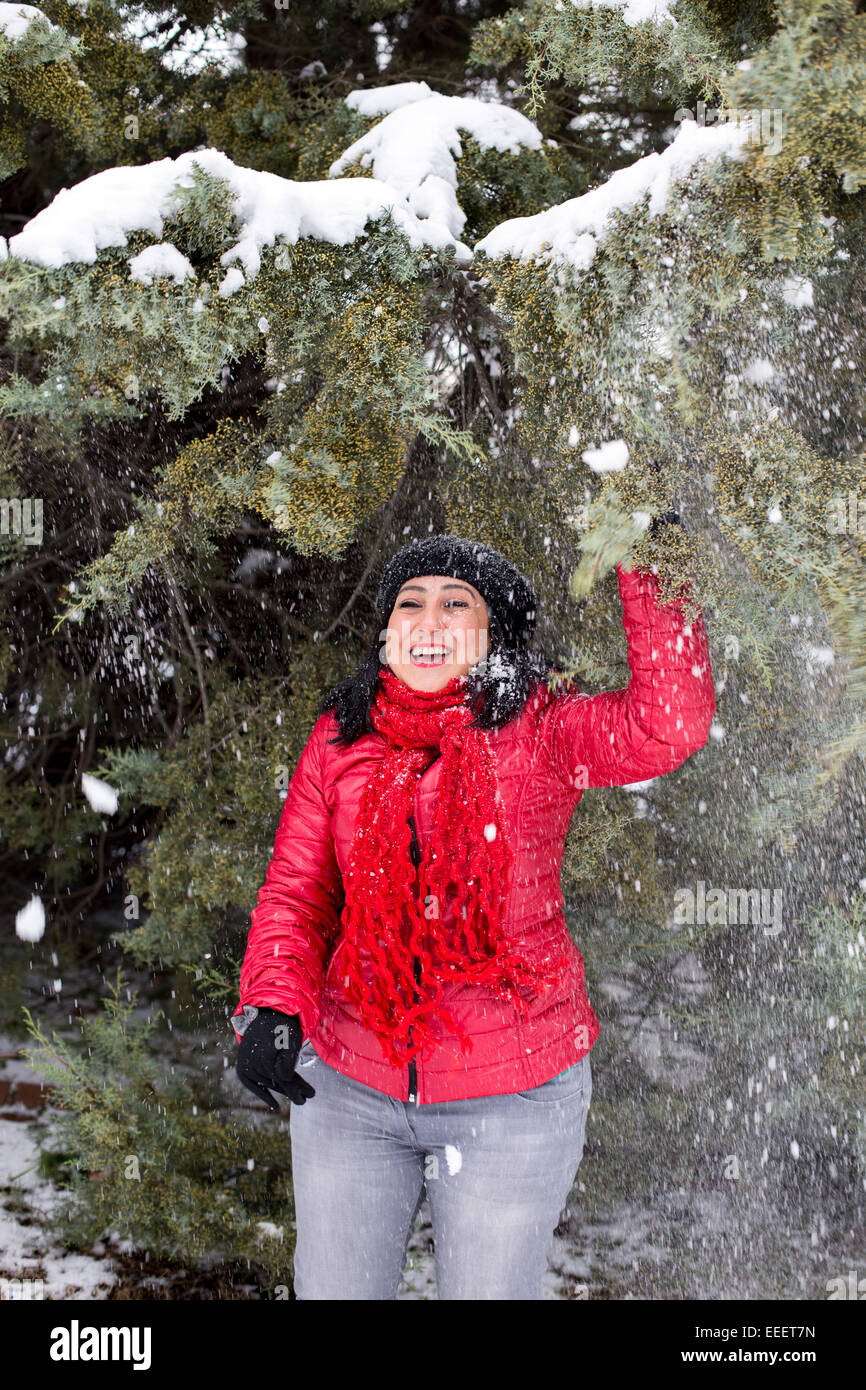 Black-haired Turkish women standing and playing under the snowy branches Stock Photo