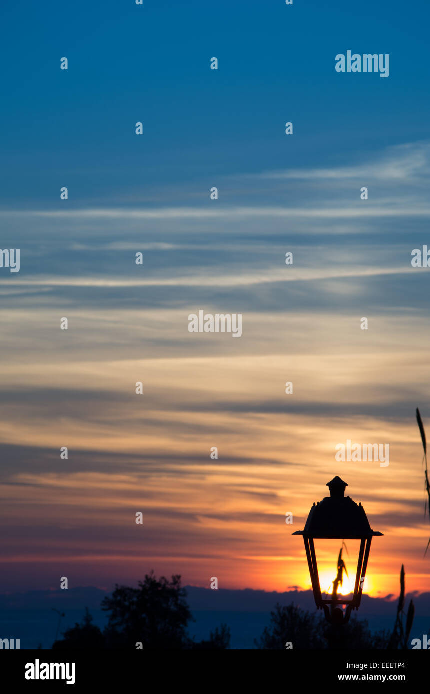 Sunset transforms a broken street lamp in a new one with solar energy