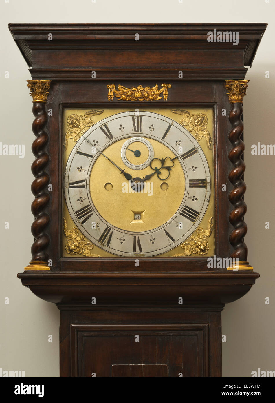 Grandfather/Grandmother clock face, with Roman numerals and twisted wood columns with Corinthian column caps. Long case clock. Stock Photo