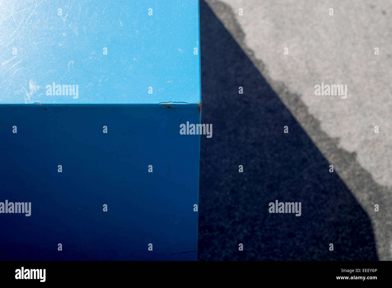 abstract view of the corner of a blue table on a concrete floor Stock Photo