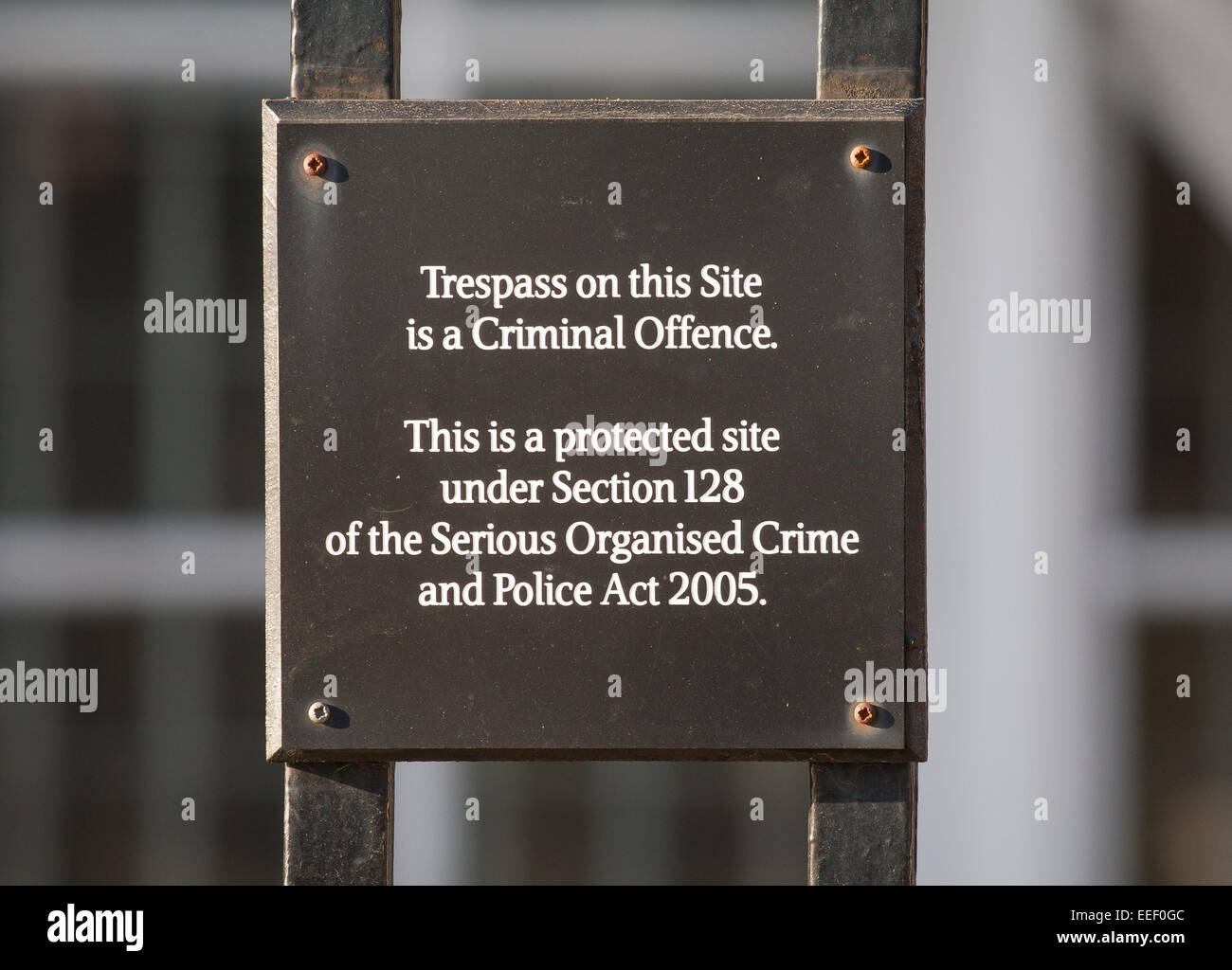 A sign reads 'Trespass on this site is a criminal offence' on the fence surrounding Portcullis House, Westminster, London Stock Photo