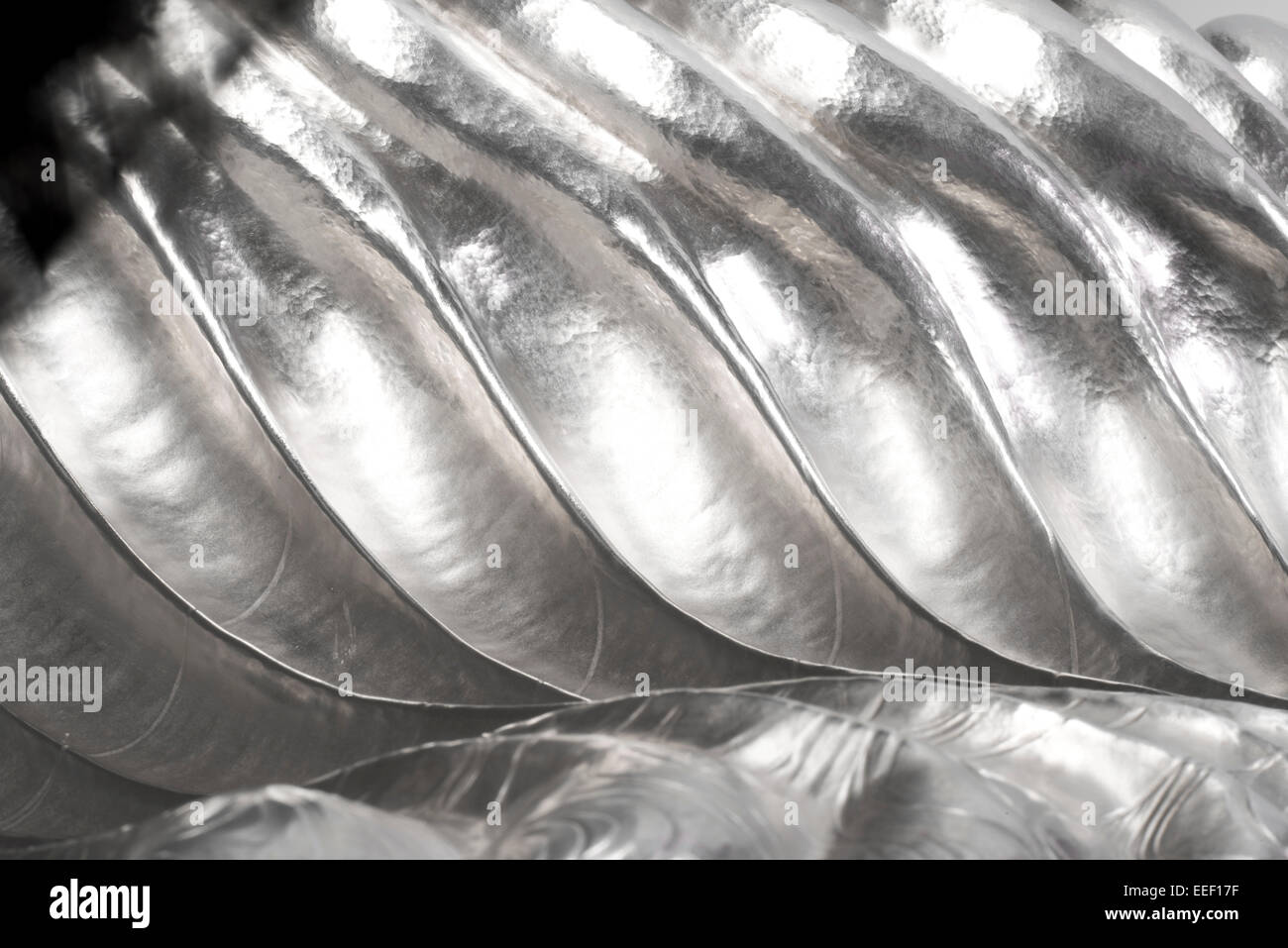 Beaten, rippled sterling silver fruit bowl close up. Designer silversmith. Quality silverware. Stock Photo