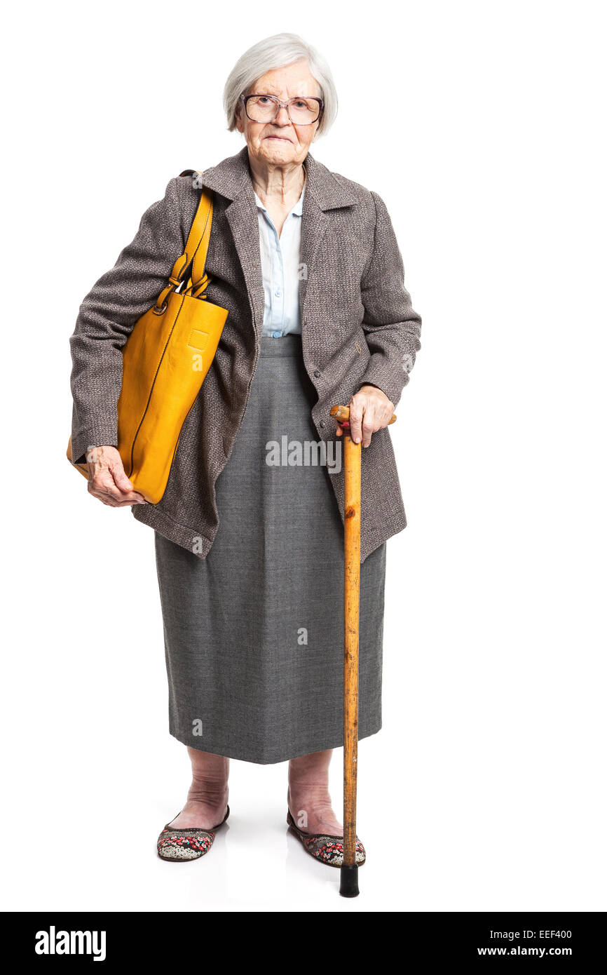 Elegant senior woman with walking stick standing over white Stock Photo