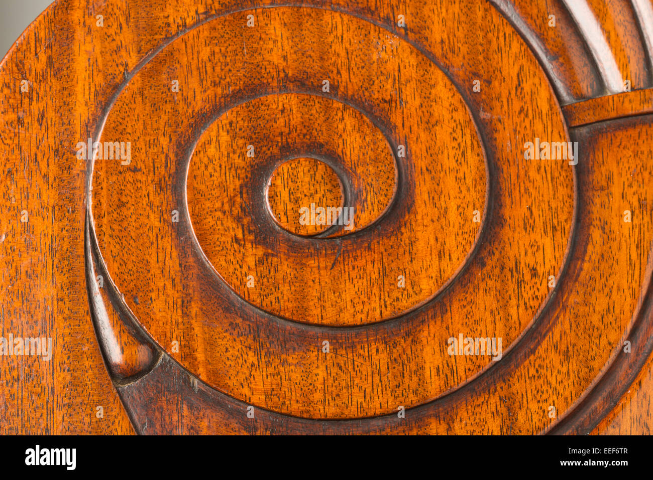 Curled swirl or spiral motif carved into mahogany antique wooden furniture. Stock Photo