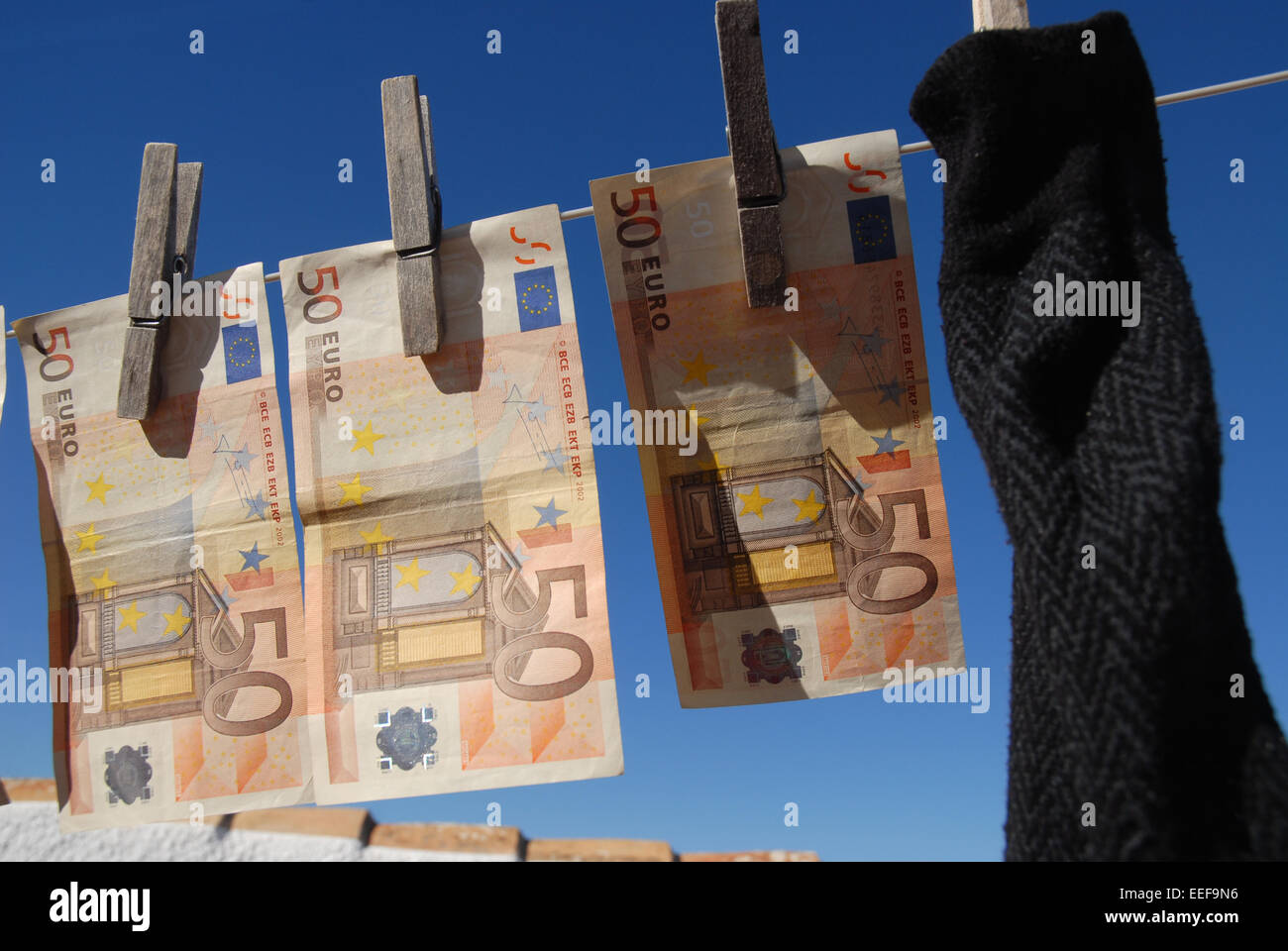 Money laundering,  euro banknotes hanging out to dry, with a sock Stock Photo