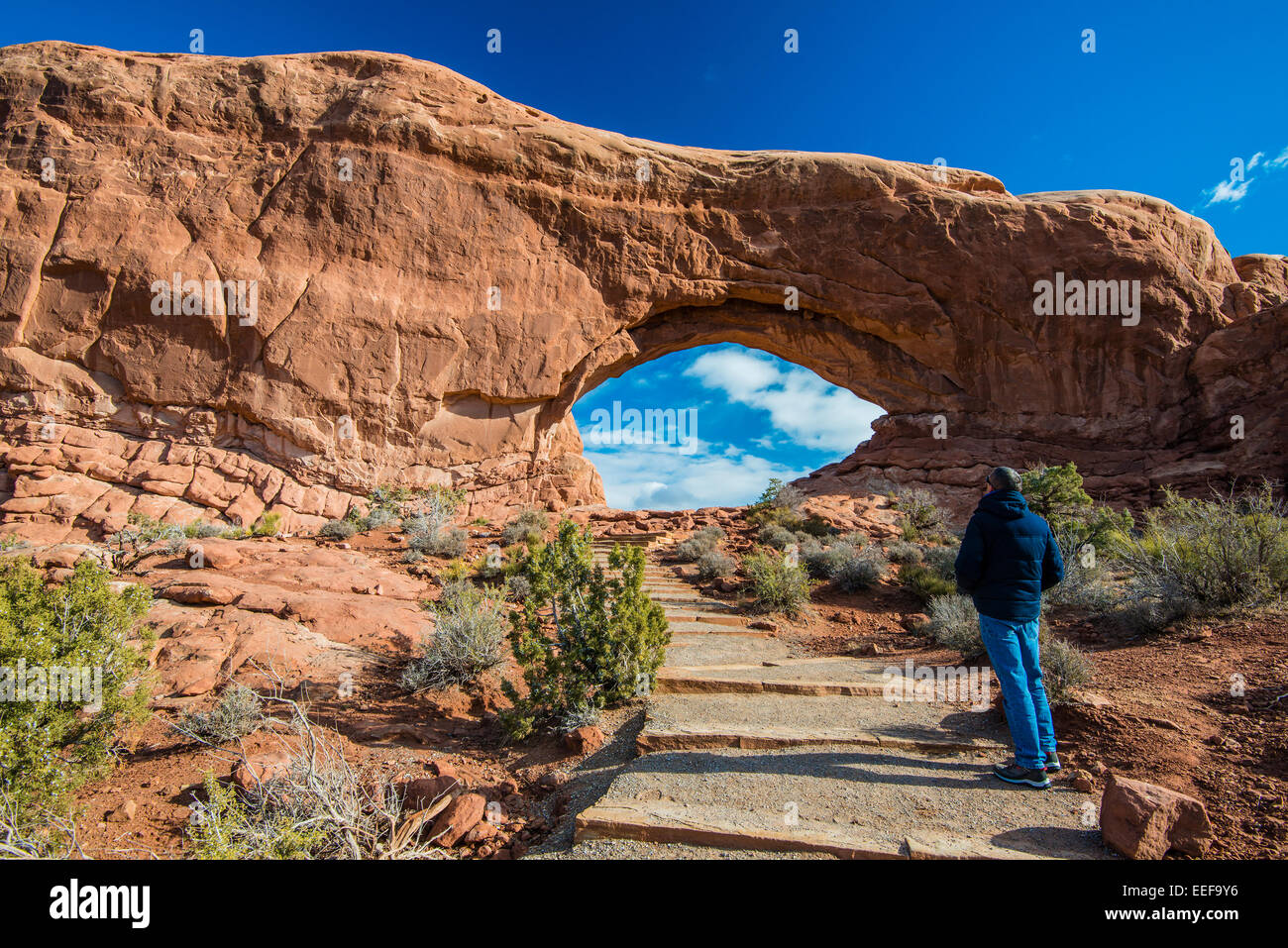 Caucasian male tourist watching the North Window Arch, Arches National Park, Utah, USA Stock Photo