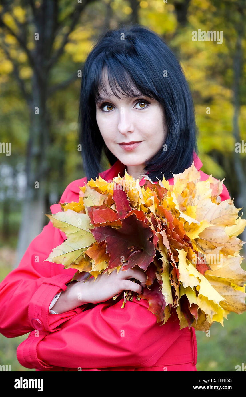 The girl walks in the Park with a bouquet of yellow maple leaves Stock ...