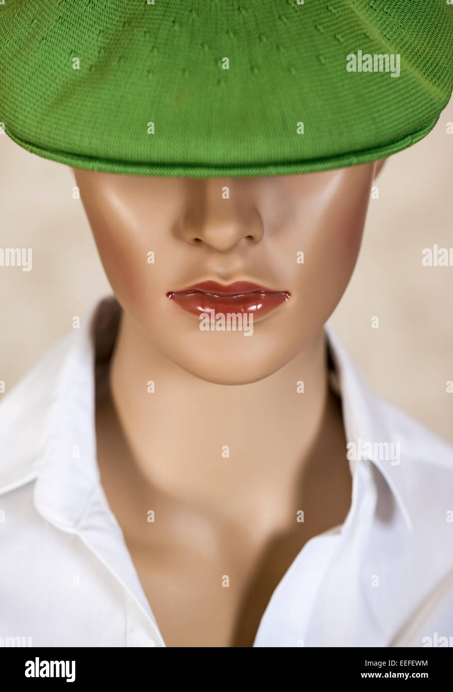 Head of a female mannequin wearing a green hat. Stock Photo