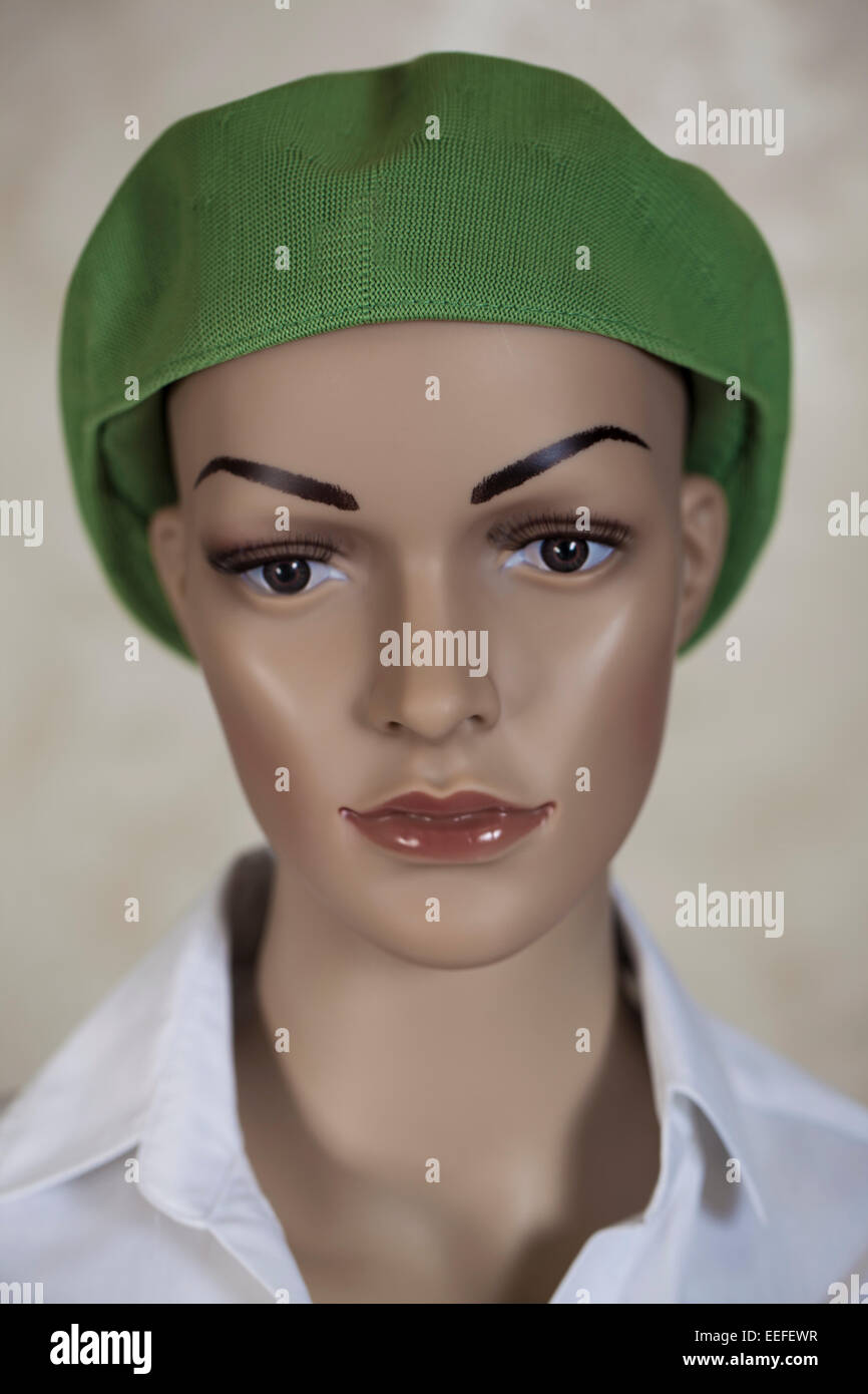 Head of a female mannequin wearing a green hat. Stock Photo