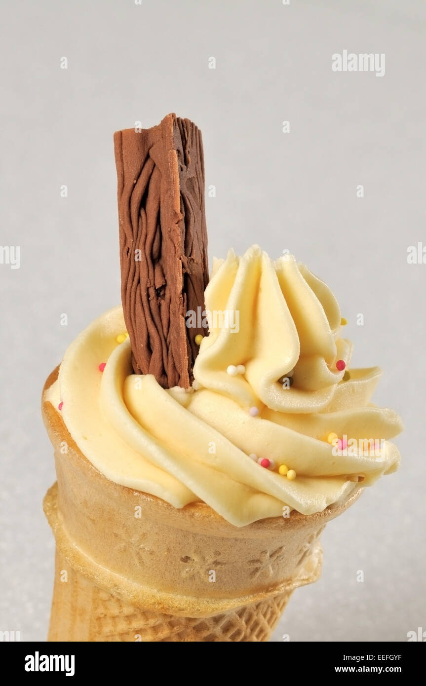 Vanilla Cone Cup Cake with chocolate flake and sprinkles. Stock Photo