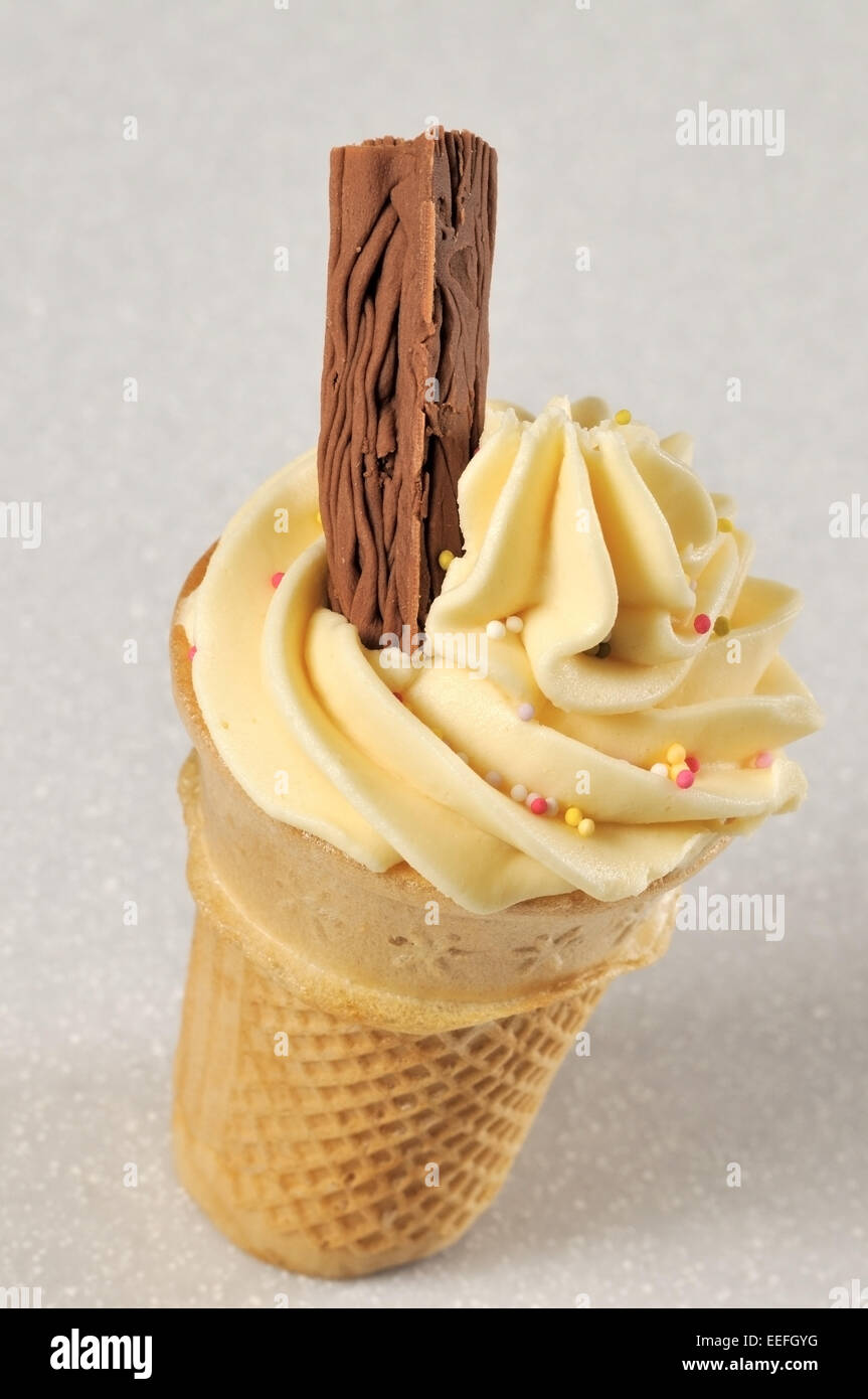 Vanilla cone cup cake with a chocolate flake and sprinkles. Stock Photo