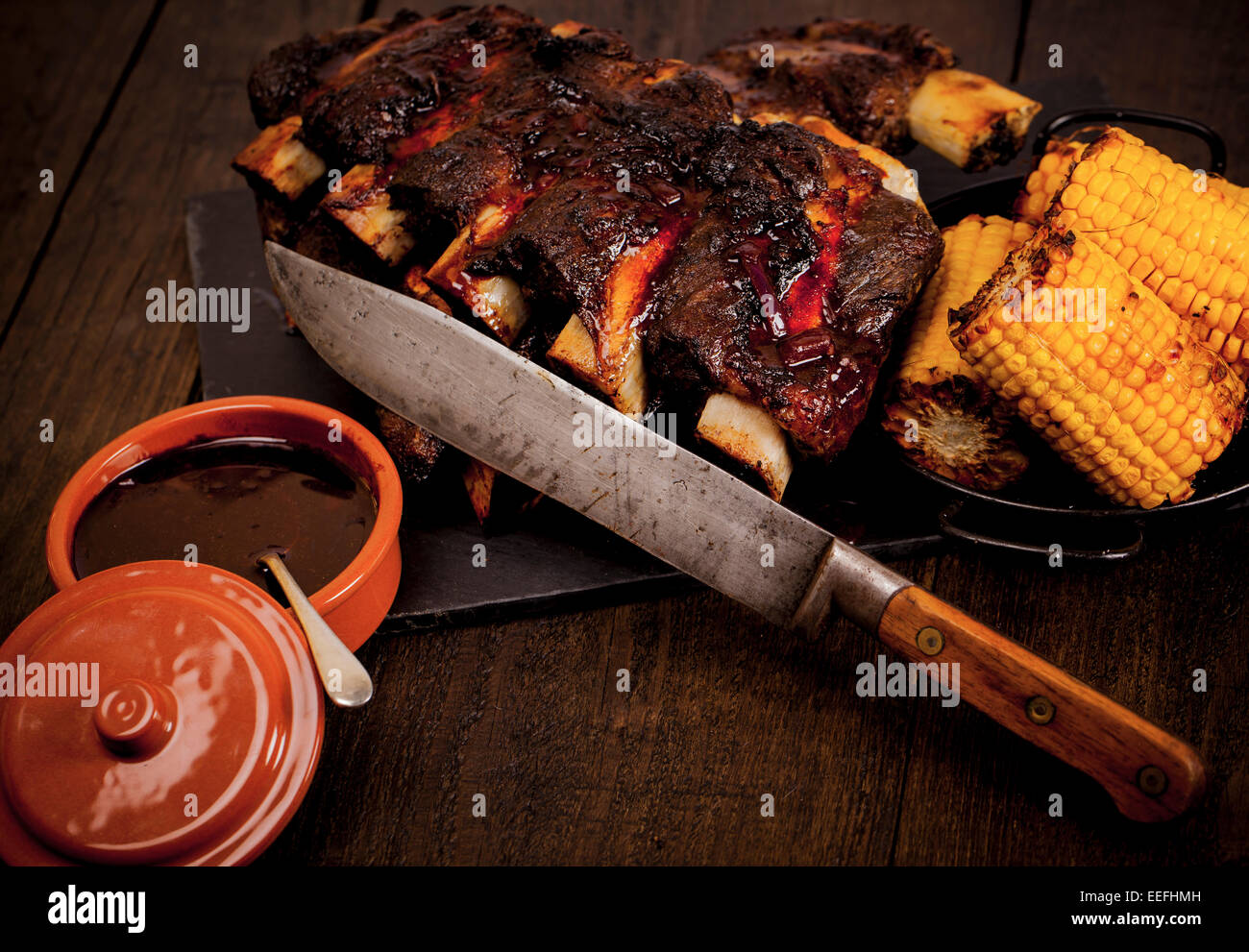 Beef ribs cooked on the BBQ and served with sweetcorn and a red wine souse. Stock Photo