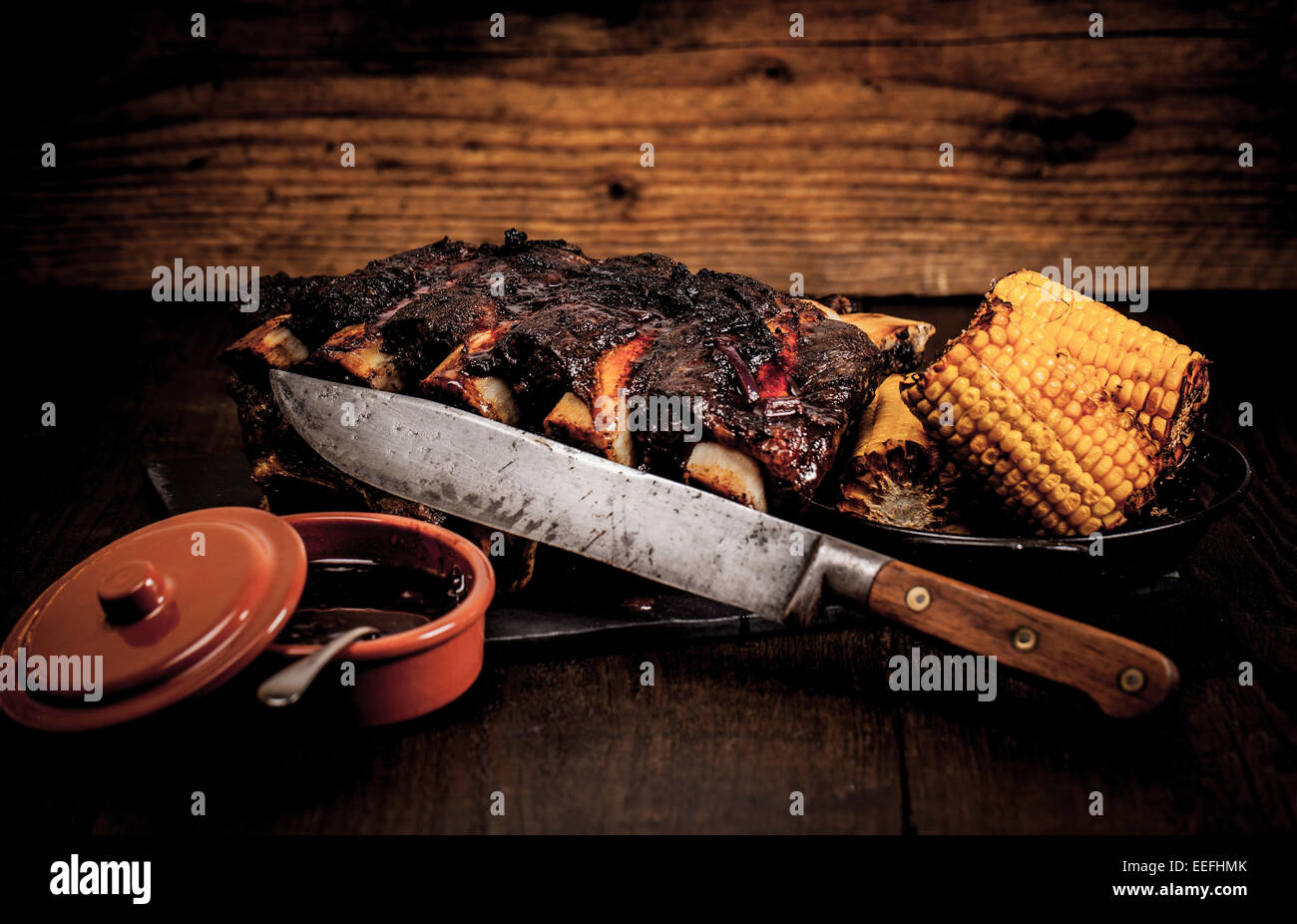Beef ribs cooked on the BBQ and served with sweetcorn and a red wine souse. Stock Photo