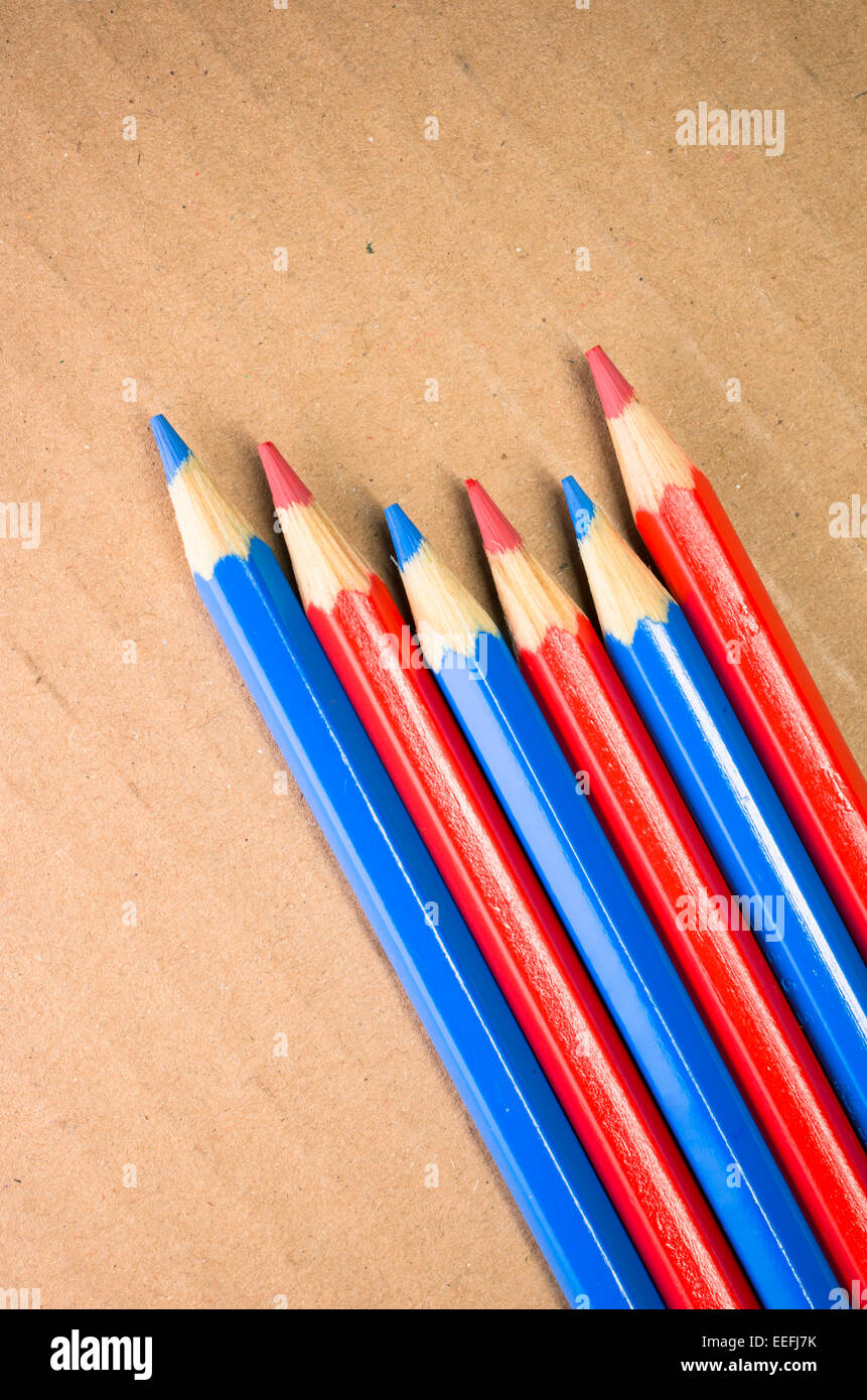 red blue colored crayons close up on a light paperboard background ...
