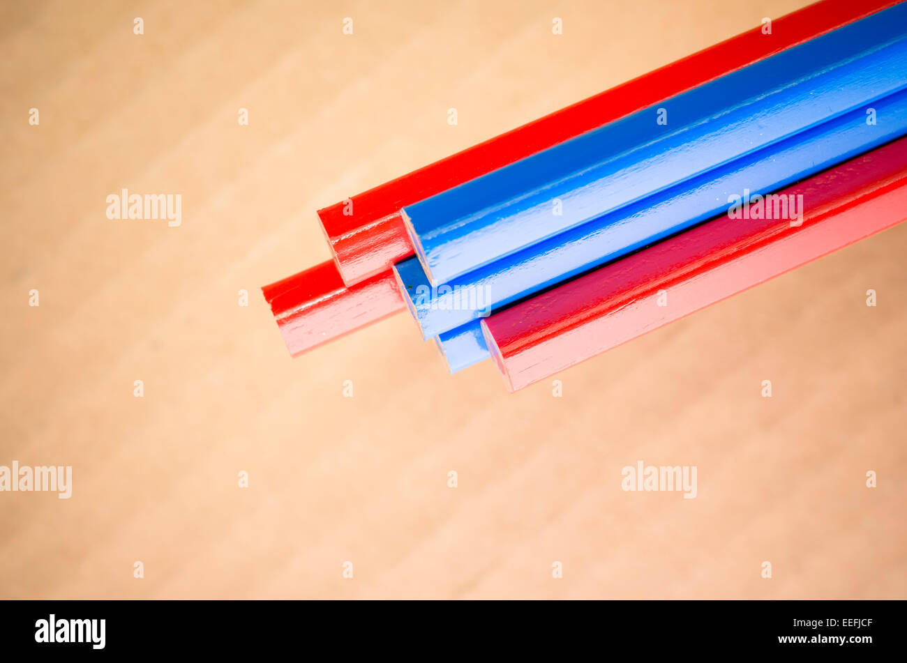 red blue colored crayons close up on a blurred light paperboard ...
