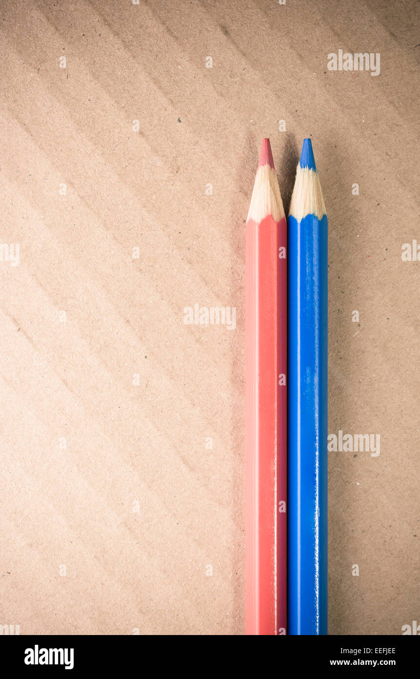 red blue colored crayons close up on a light paperboard background ...