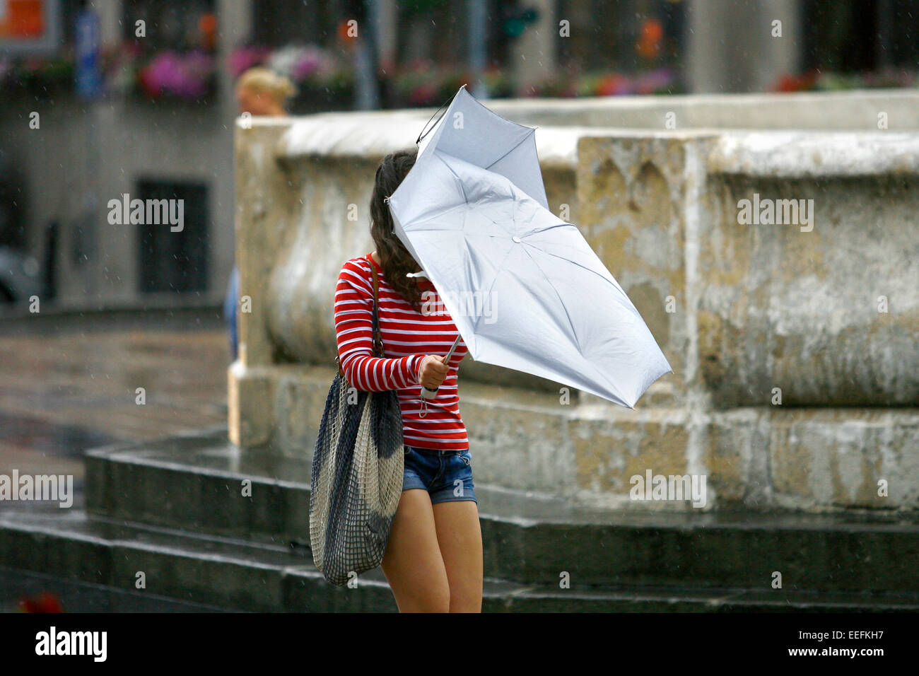 Woman walking with umbrellas in the rain Stock Photo - Alamy