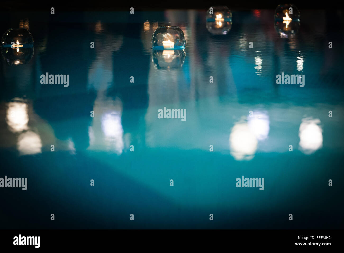 Candles in glass bowls floating in swimming pool Stock Photo Alamy