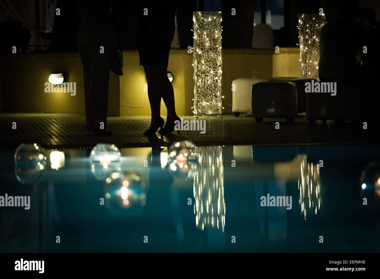Pool party candles in glass bowls floating in swimming pool Stock