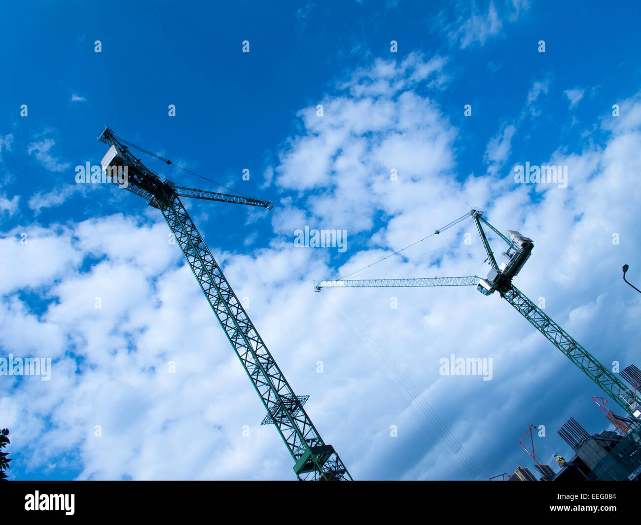 Cranes in a construction site against clouds in the sky Stock Photo - Alamy