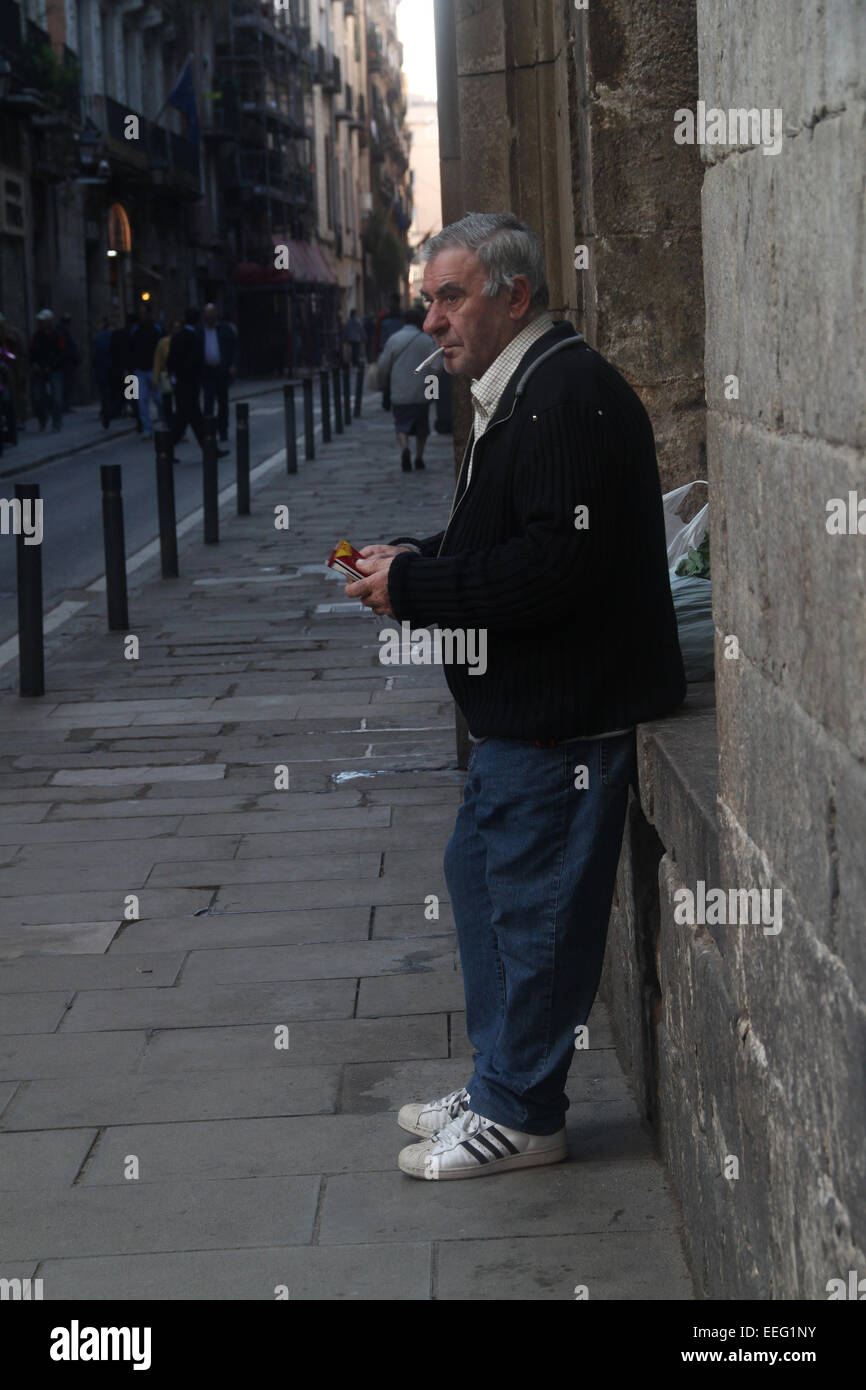 Man standing in the street smoking in El Raval, Barcelona, Catalonia, Spain Stock Photo