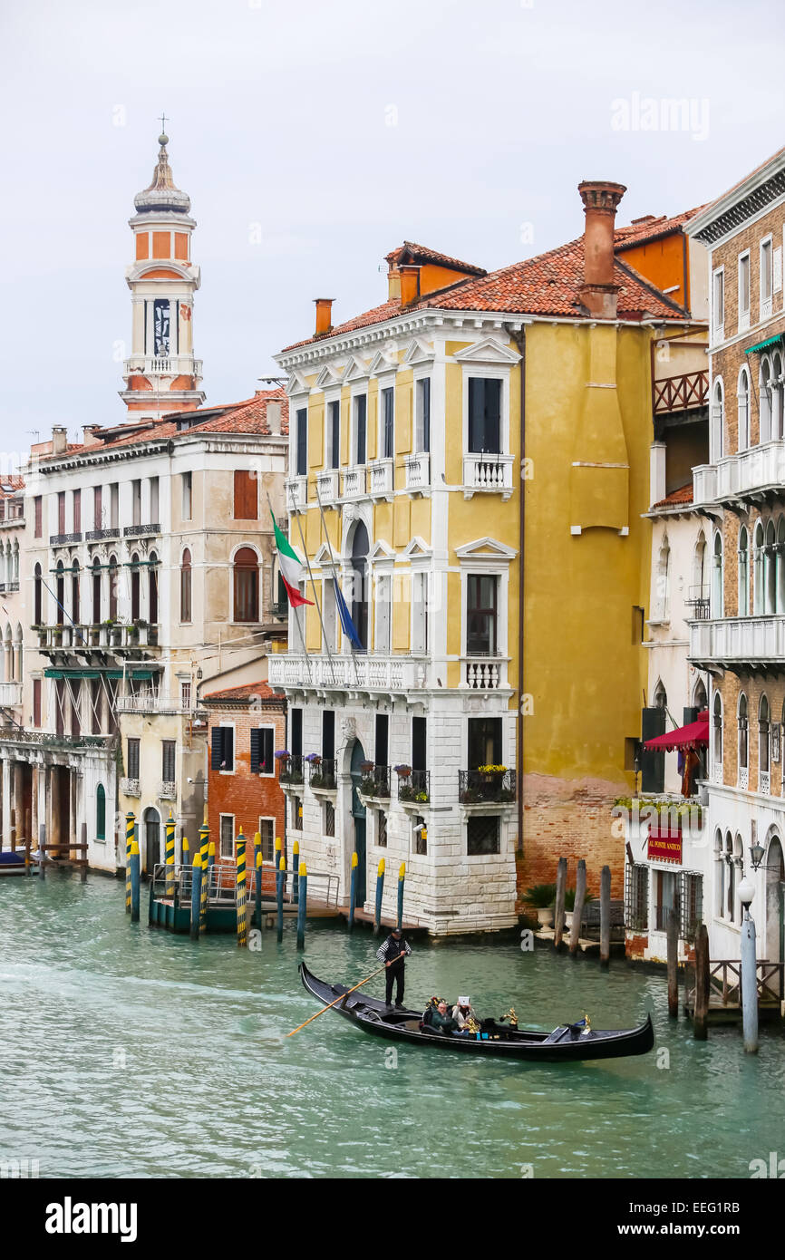 VENICE, ITALY - FEBRUARY 15 : A gondola with tourists sailing through a grand canal on February 15th, 2014 in Venice, Italy. Stock Photo