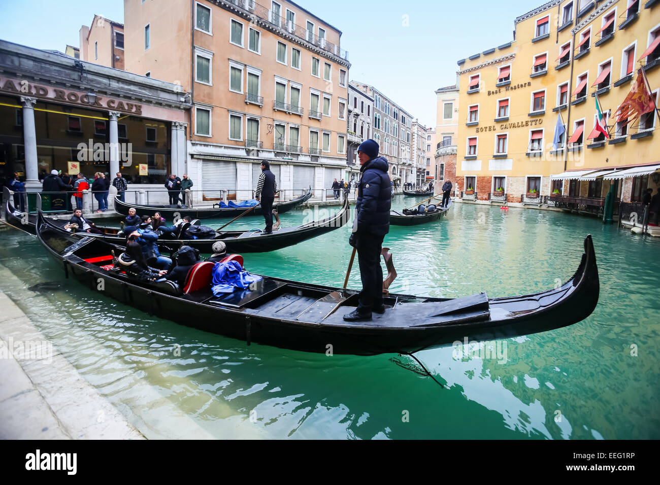 Tourists and gondolas at a gondola station next to Hard rock cafe and Hotel Cavalletto in Venice, Italy. Stock Photo