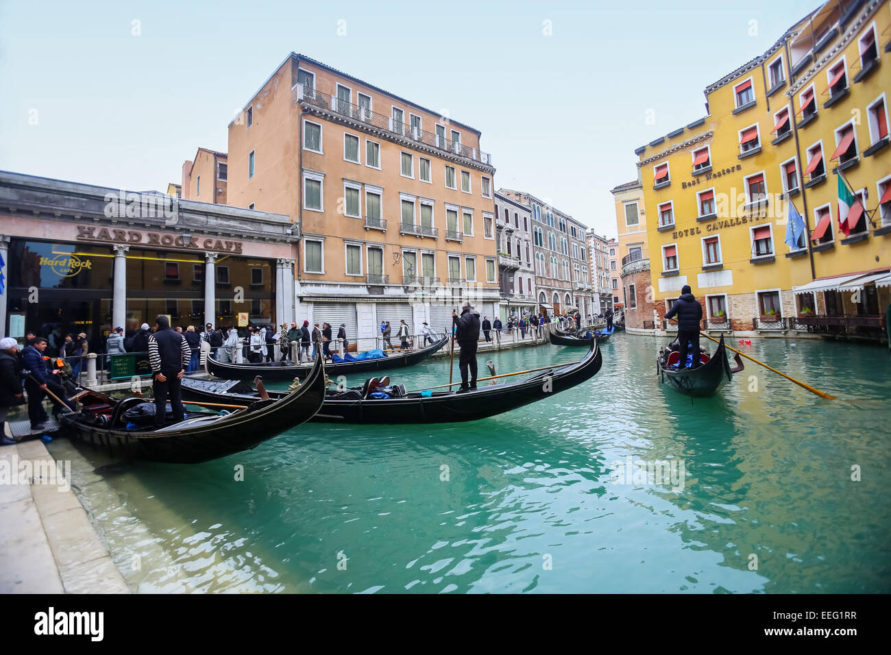 Tourists and gondolas at a gondola station next to Hard rock cafe and Hotel Cavalletto in Venice, Italy. Stock Photo
