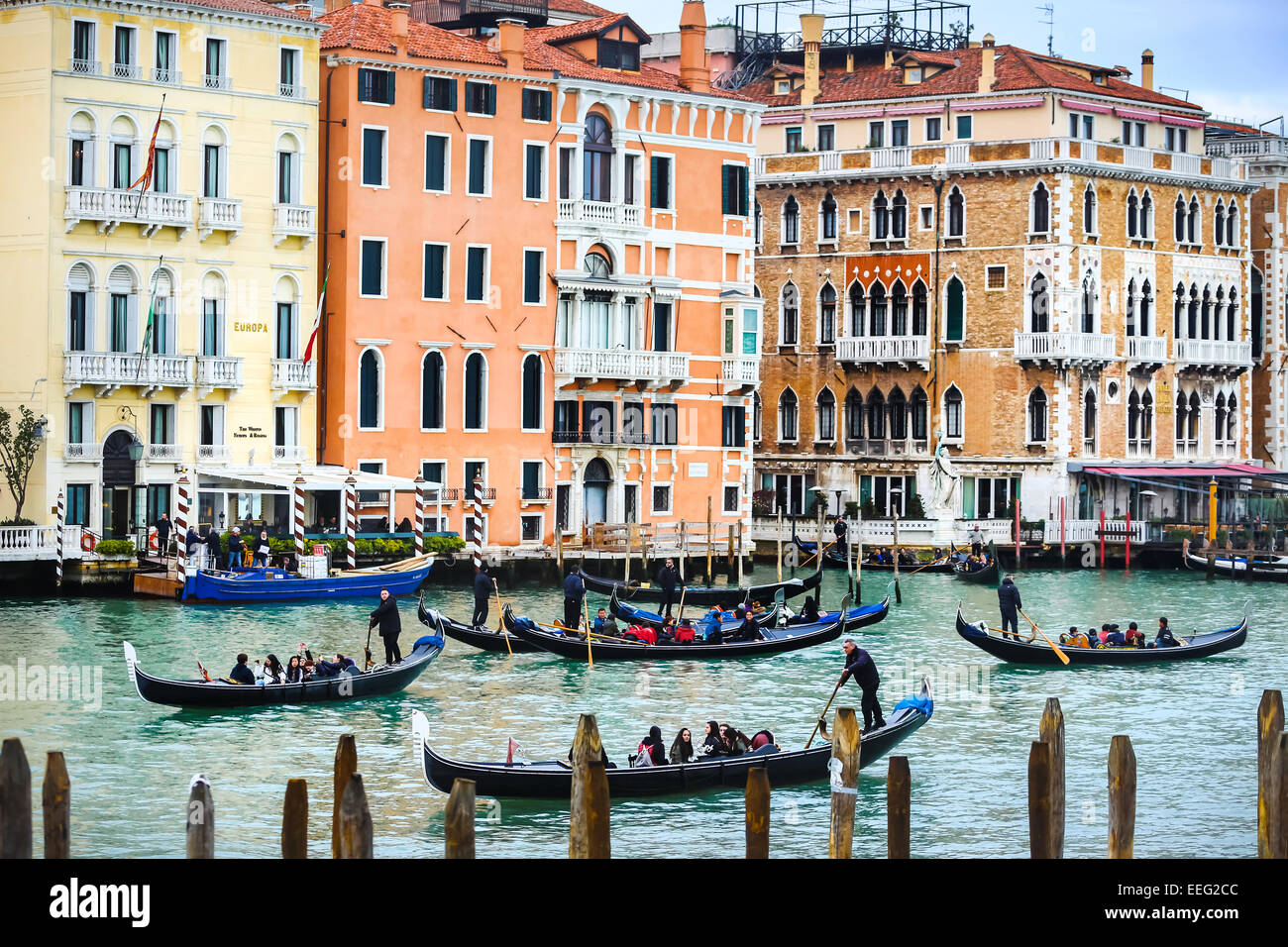 A view of gondolas with tourists sailing through a water canal in Venice, Italy. Stock Photo