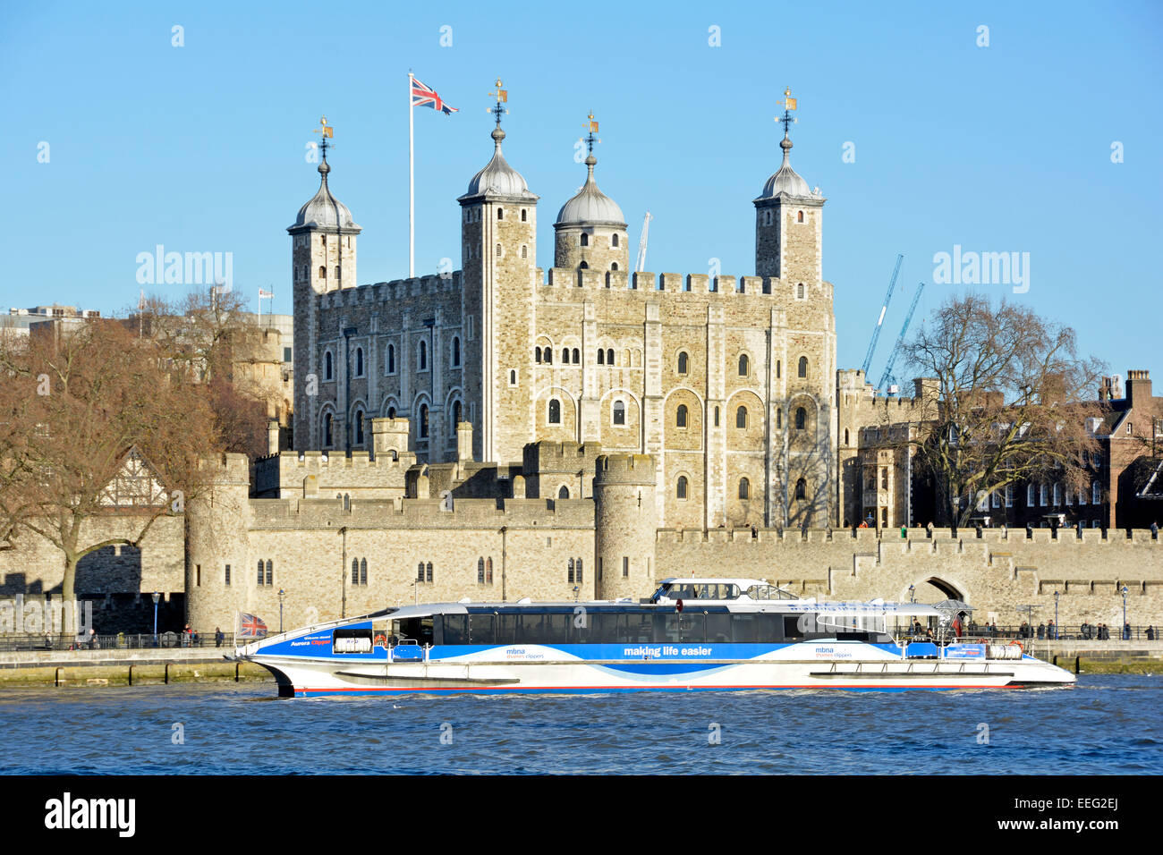 Thames clipper high speed catamaran commuter and tourist river bus service passing the Tower of London England UK Stock Photo