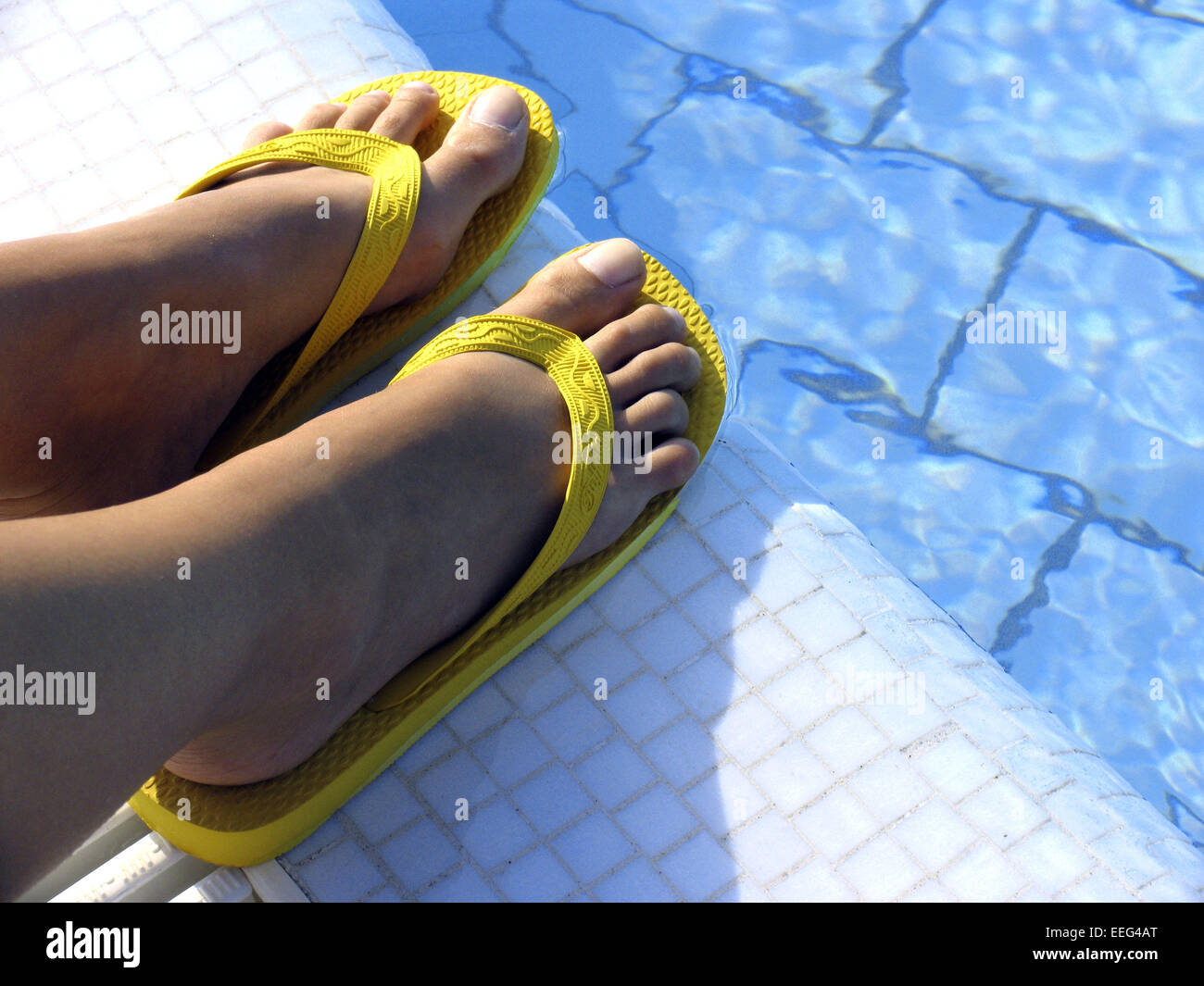 Aussen Pool Fuesse Frauenfuesse Schuhe Badeschuhe Flip-Flops Farbe Gelb  Poolrand Wasser Blau Sommer Urlaub Freizeit Holiday Swim Stock Photo - Alamy