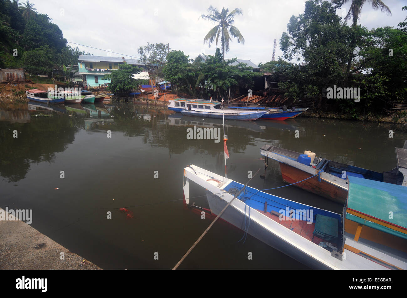 Boats transporting timber to/from sawmills on the riverbank in Sorong, Papua province, Indonesia. No PR or MR Stock Photo