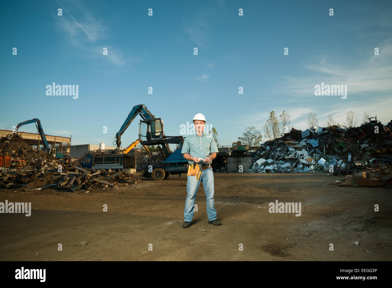 portrait of happy caucasian worker standing in metal landfill outdoors Stock Photo