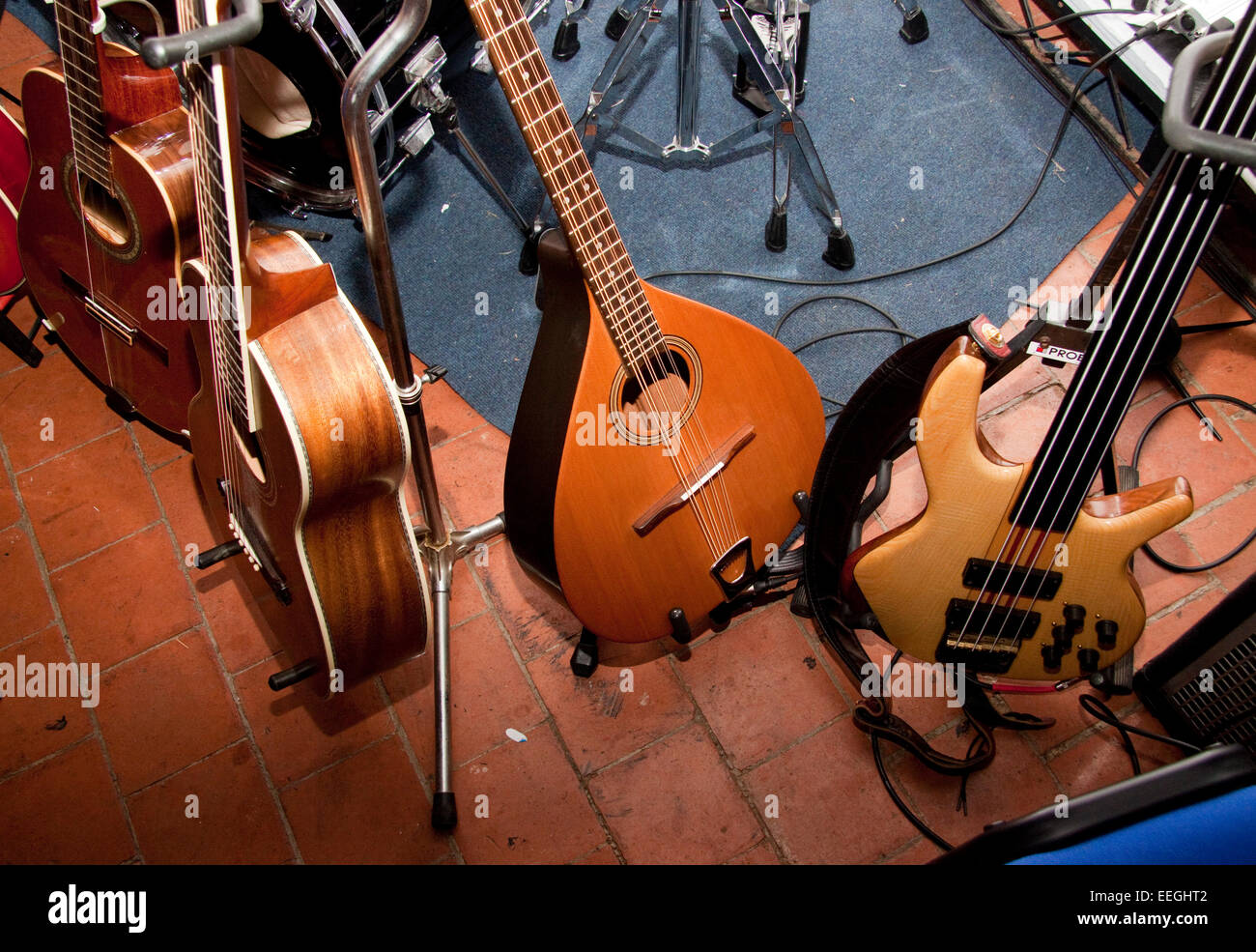 Two acoustic and one bass guitar and a Greek bouzouki on stands Stock Photo  - Alamy