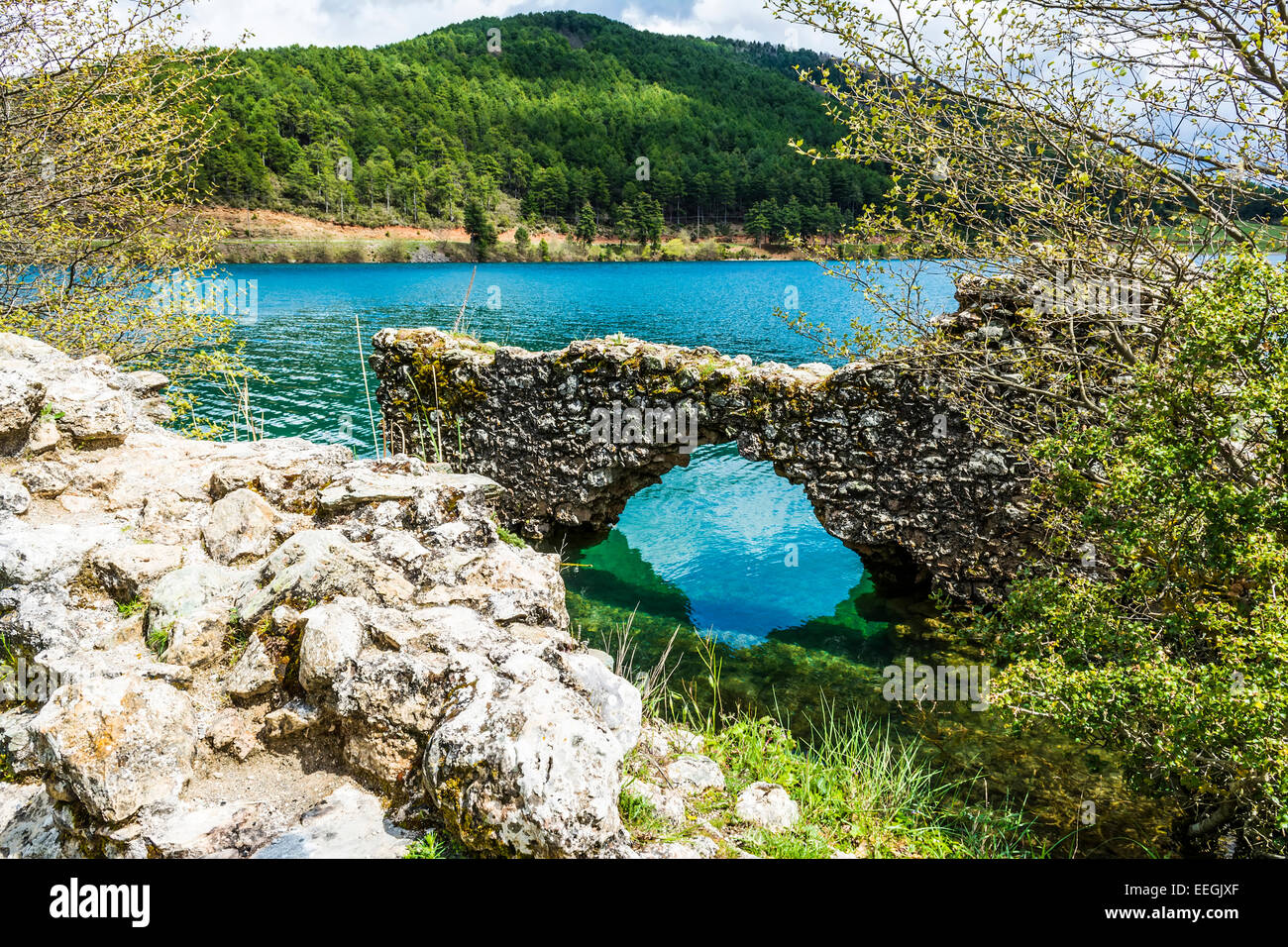 Stone wall at a blue lake under a cloudy sky - landscape Stock Photo ...