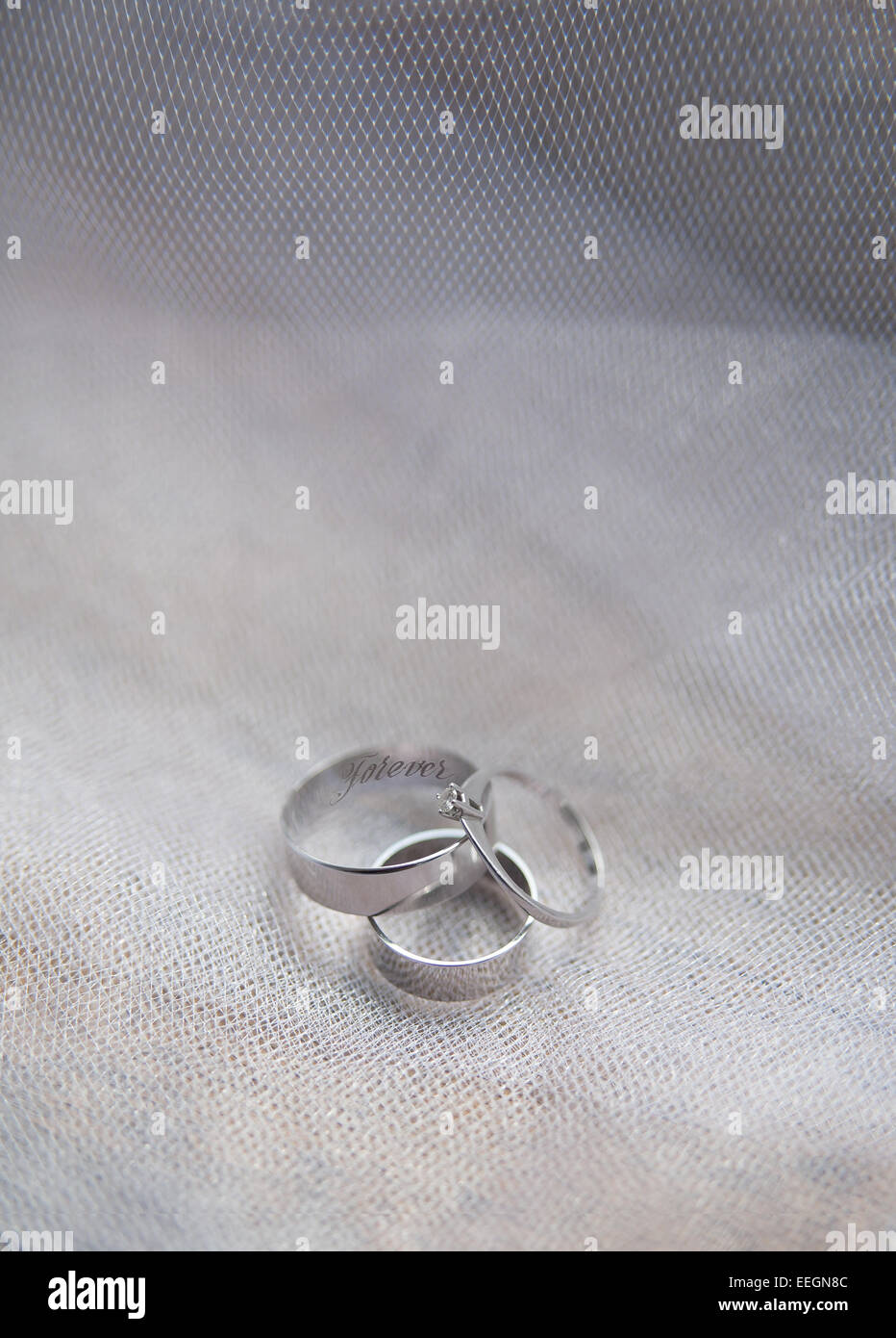 Platinum engagement and wedding ringson on fabric Stock Photo