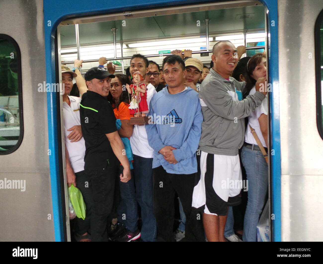 Tondo, Philippines. 18th January, 2015. People squeezing at the train station just to attend the holy mass of Pope Francis at Quirino Grandstand in Manila. Some people bring their image of the Infant Jesus for Pope's Blessing. Credit:  Sherbien Dacalanio / Alamy Live News Stock Photo