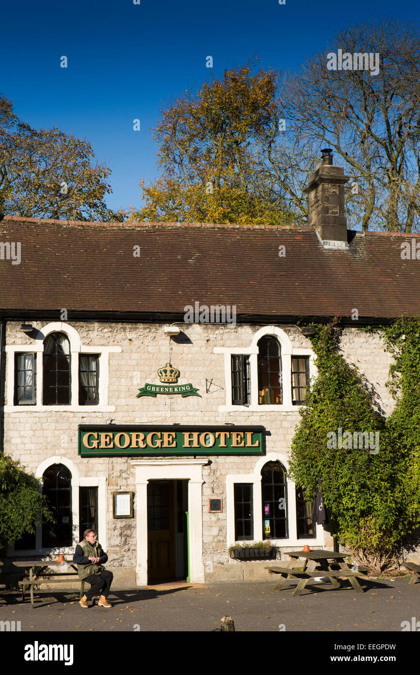 UK, Derbyshire, Tideswell, smoker outside the George Hotel public house in autumn Stock Photo