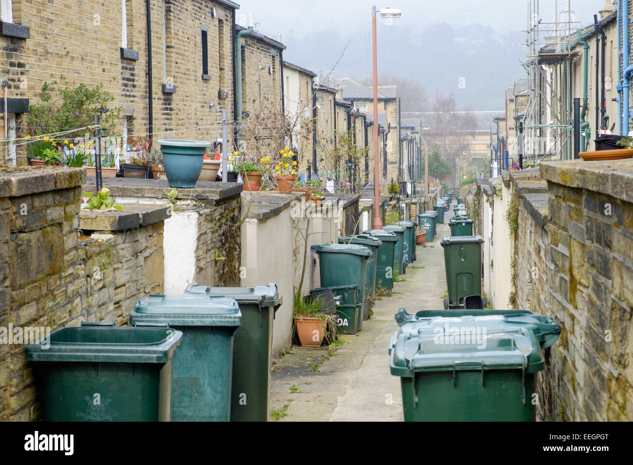 The back alley full of wheelie bins, in the traditional Victorian northern mill town of Saltaire, in Yorkshire, UK. Stock Photo