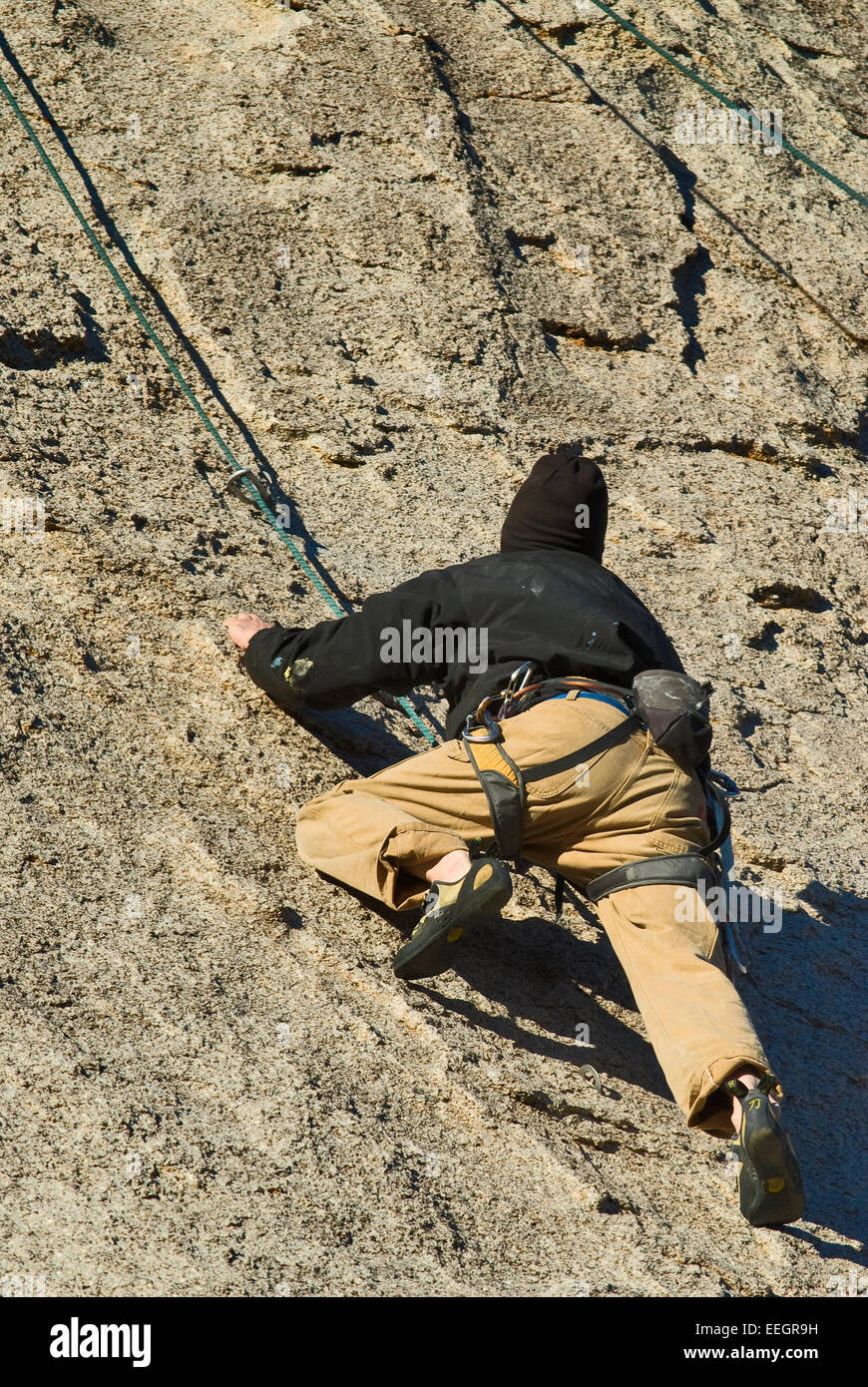 Rock climber scaling exposed rock face in Alabama Hills near Lone Pine in Eastern Sierra Nevada, California, USA Stock Photo