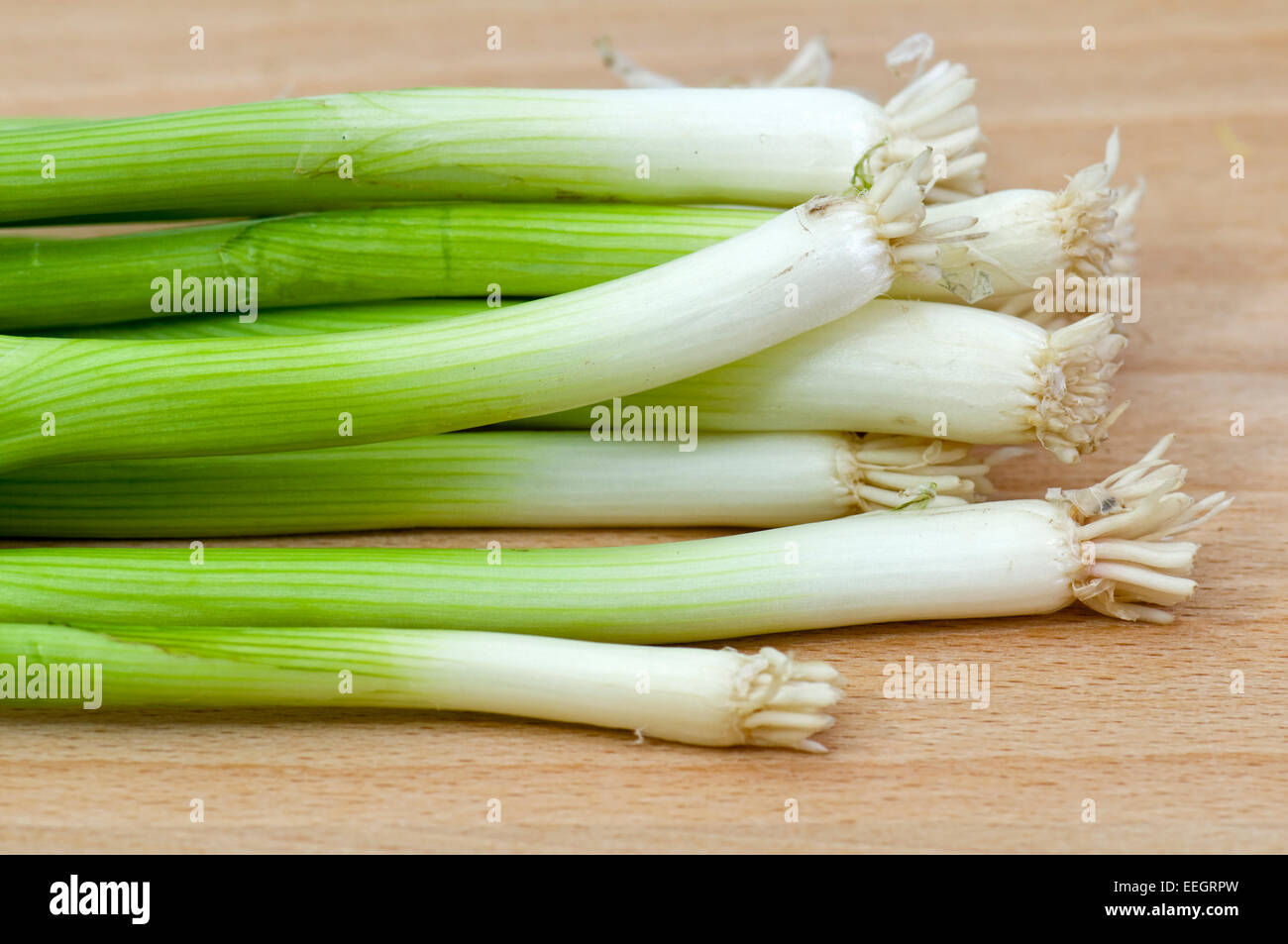 Spring onions or scallions on chopping board Stock Photo