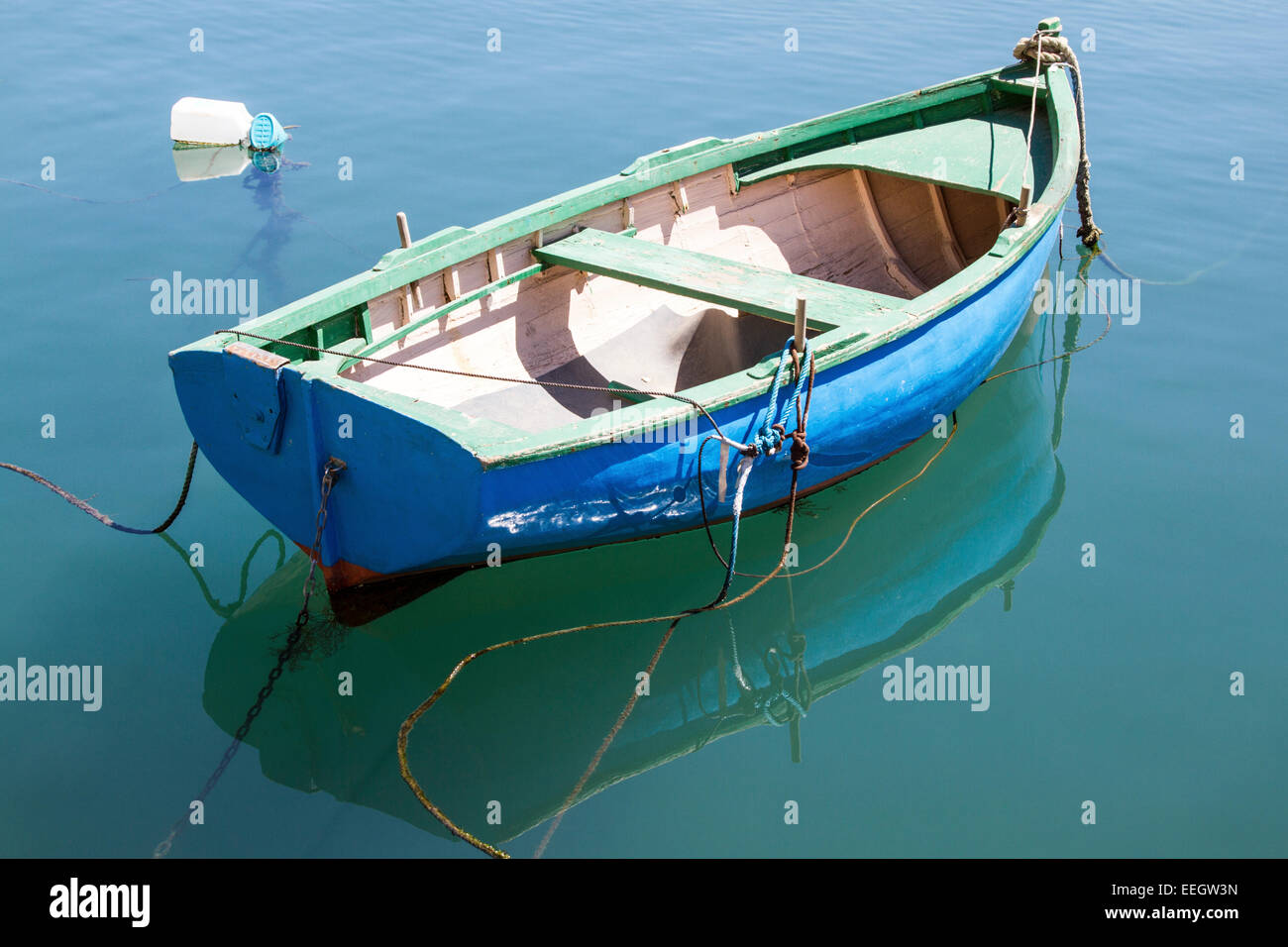 A rowing boat with reflection in the water of Spinola Bay which is within St Julians Bay Malta Stock Photo