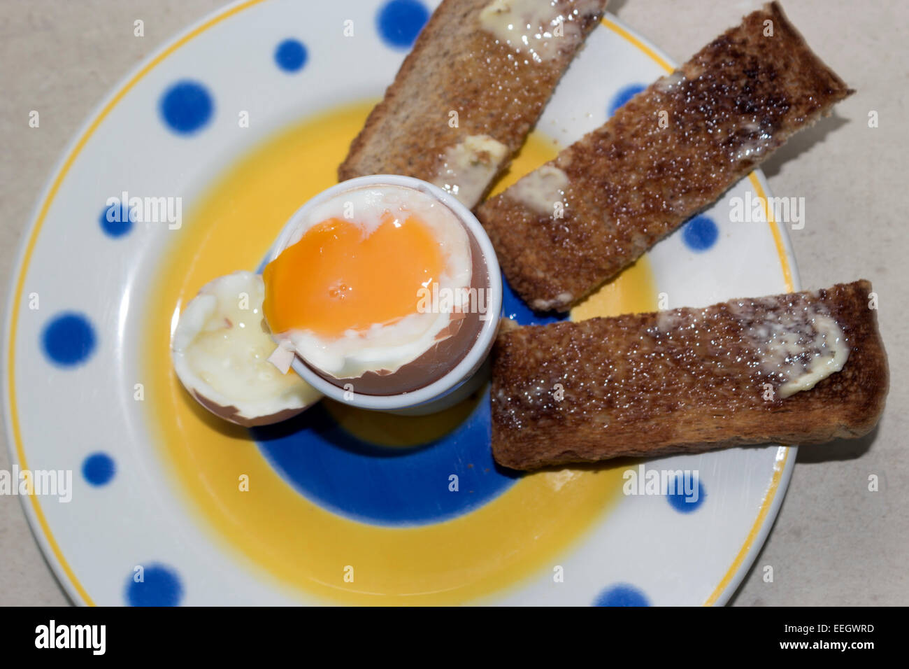 Soft boiled egg in eggcup with toast soldiers. Stock Photo
