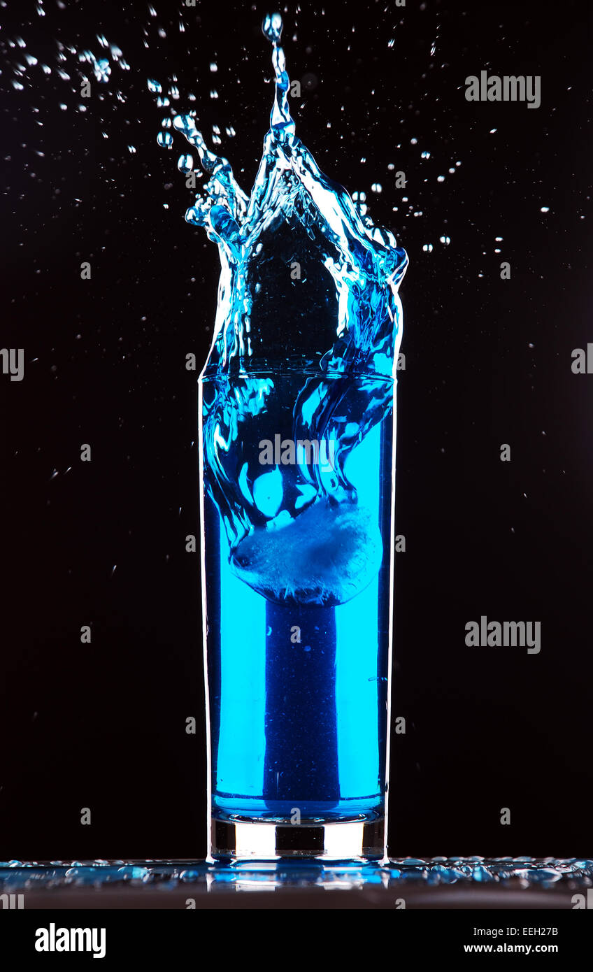 blue cocktail splashing on dark background Stock Photo - Alamy