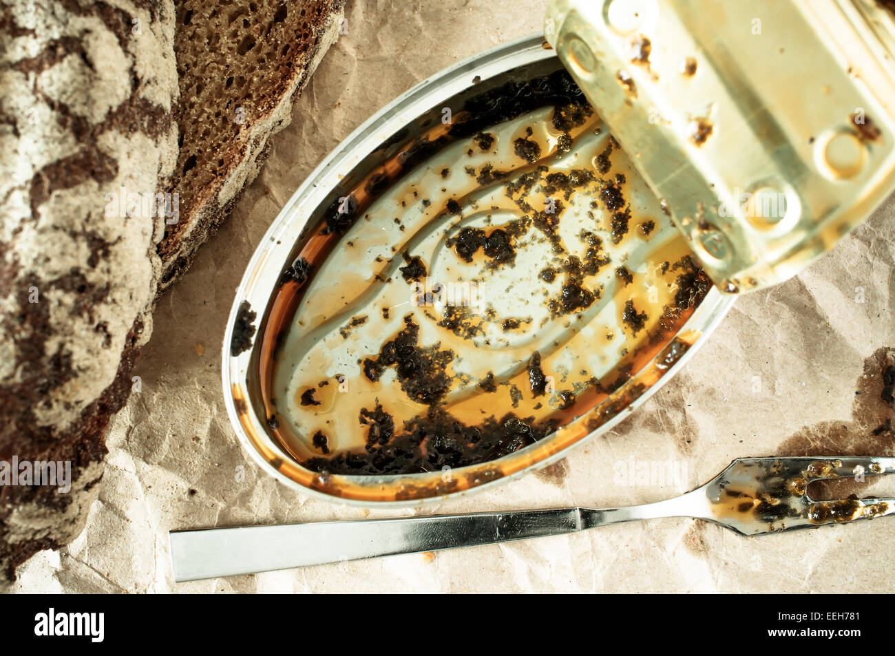 Empty tin can with the remains of food and fork Stock Photo